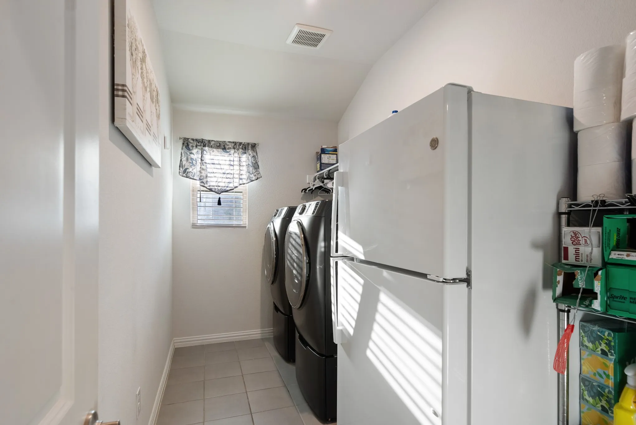 Compact utility space featuring neutral wall paint and tile flooring