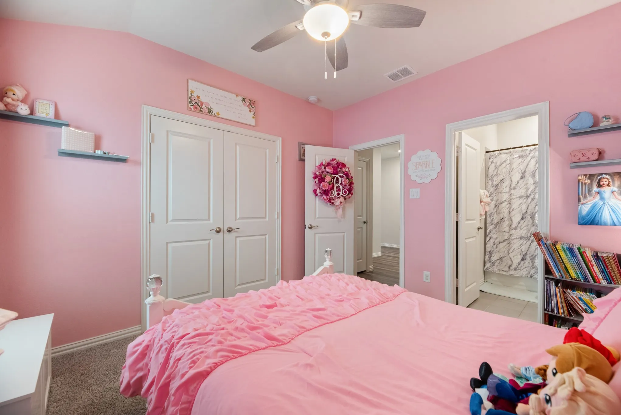 Carpeted bedroom featuring a ceiling fan, double-panel closet doors, and recessed shelving