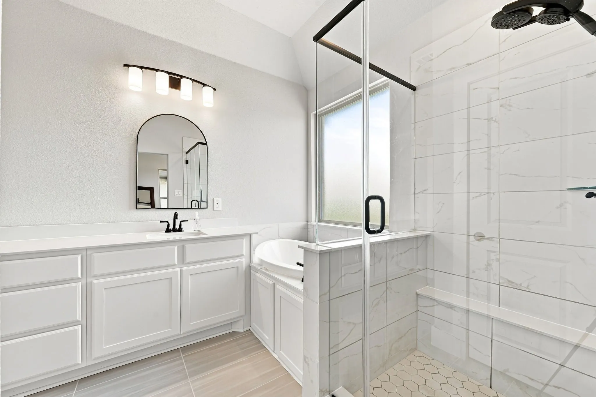 Relax in this luxurious bath with a stand alone shower with a bench and garden tub.