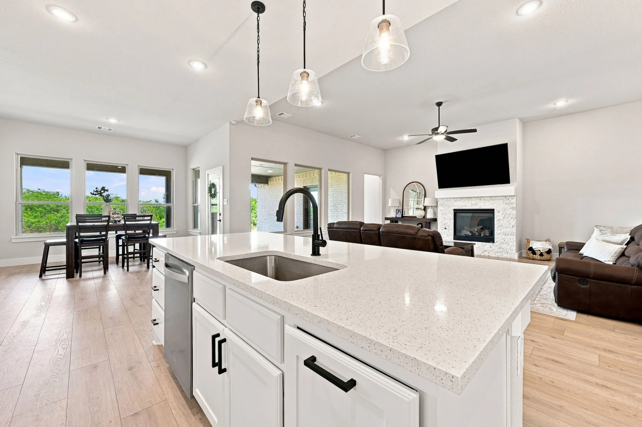 Stainless steel appliances with undermount sink, black faucet and granite counters.