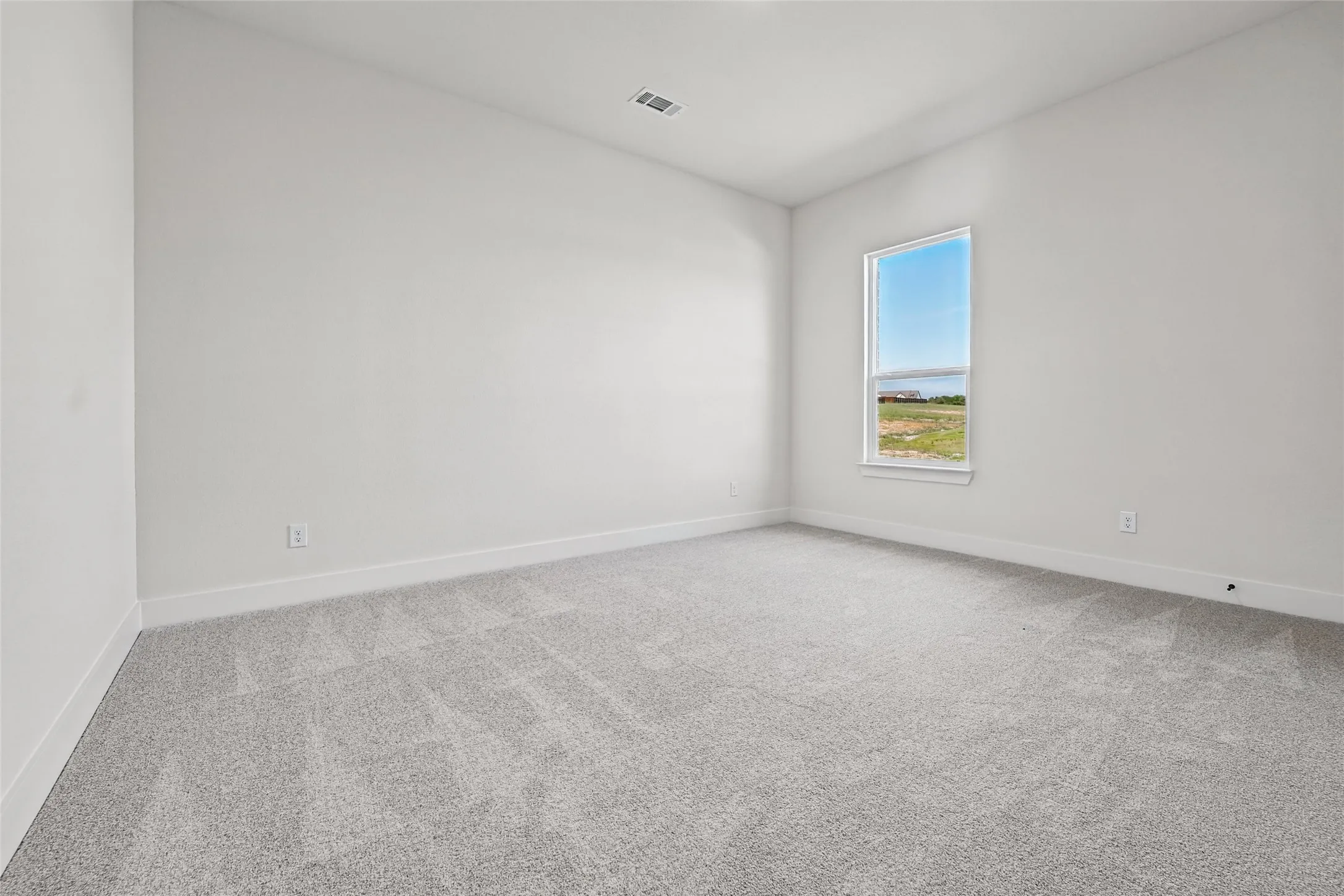 Neutral color palette, carpeted flooring, large window, clean white walls