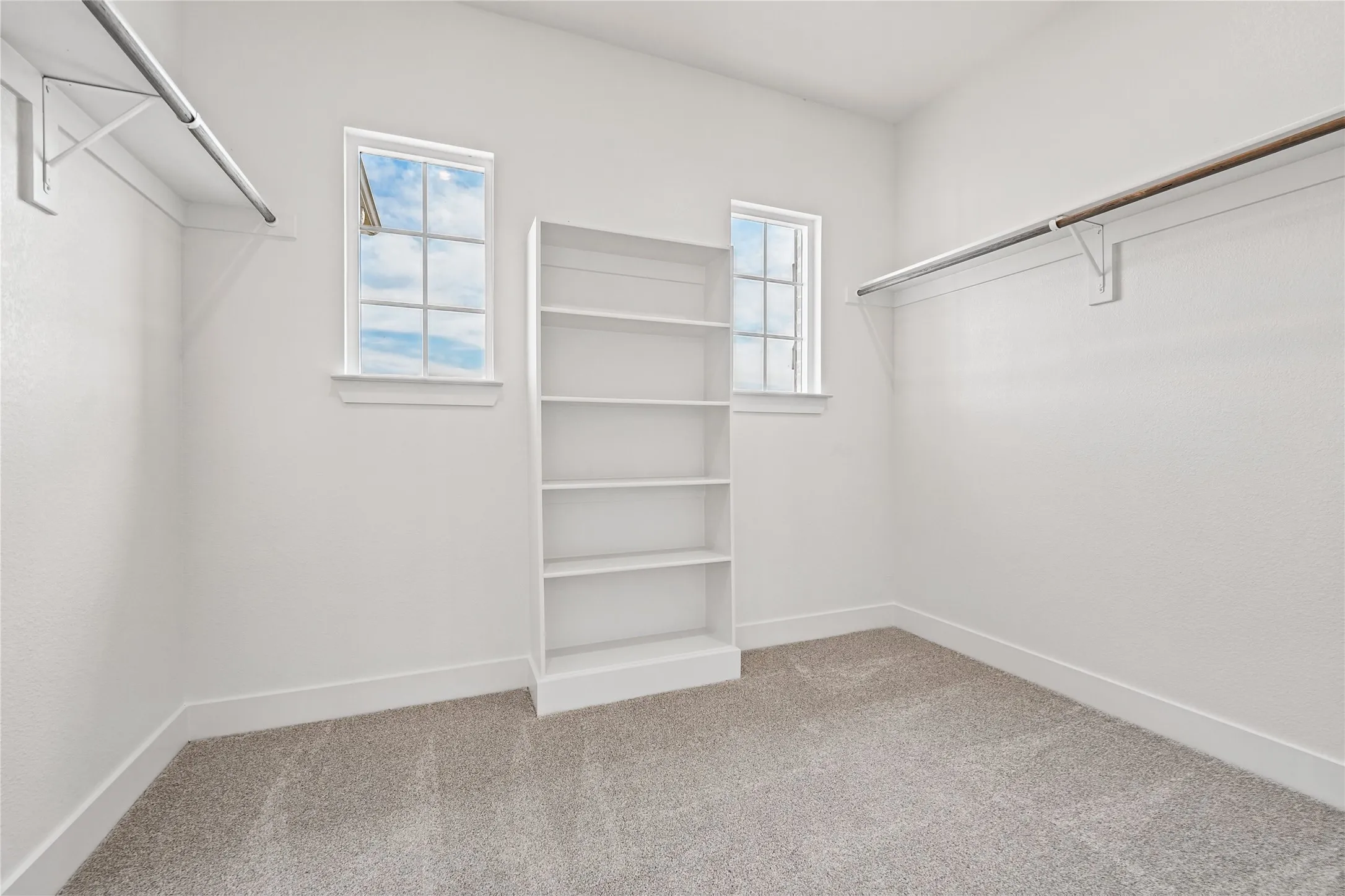 Built-in shelving unit, dual windows with gridded panes, and two clothing rods with shelving