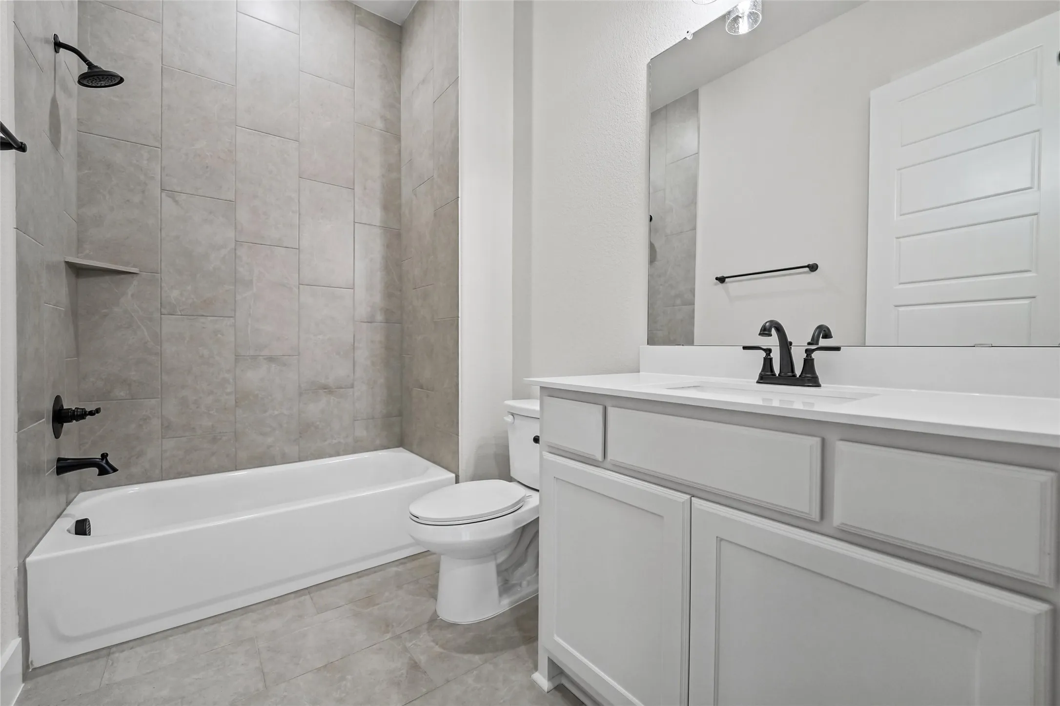 White vanity with a solid surface countertop, undermount sink, and matte black faucet