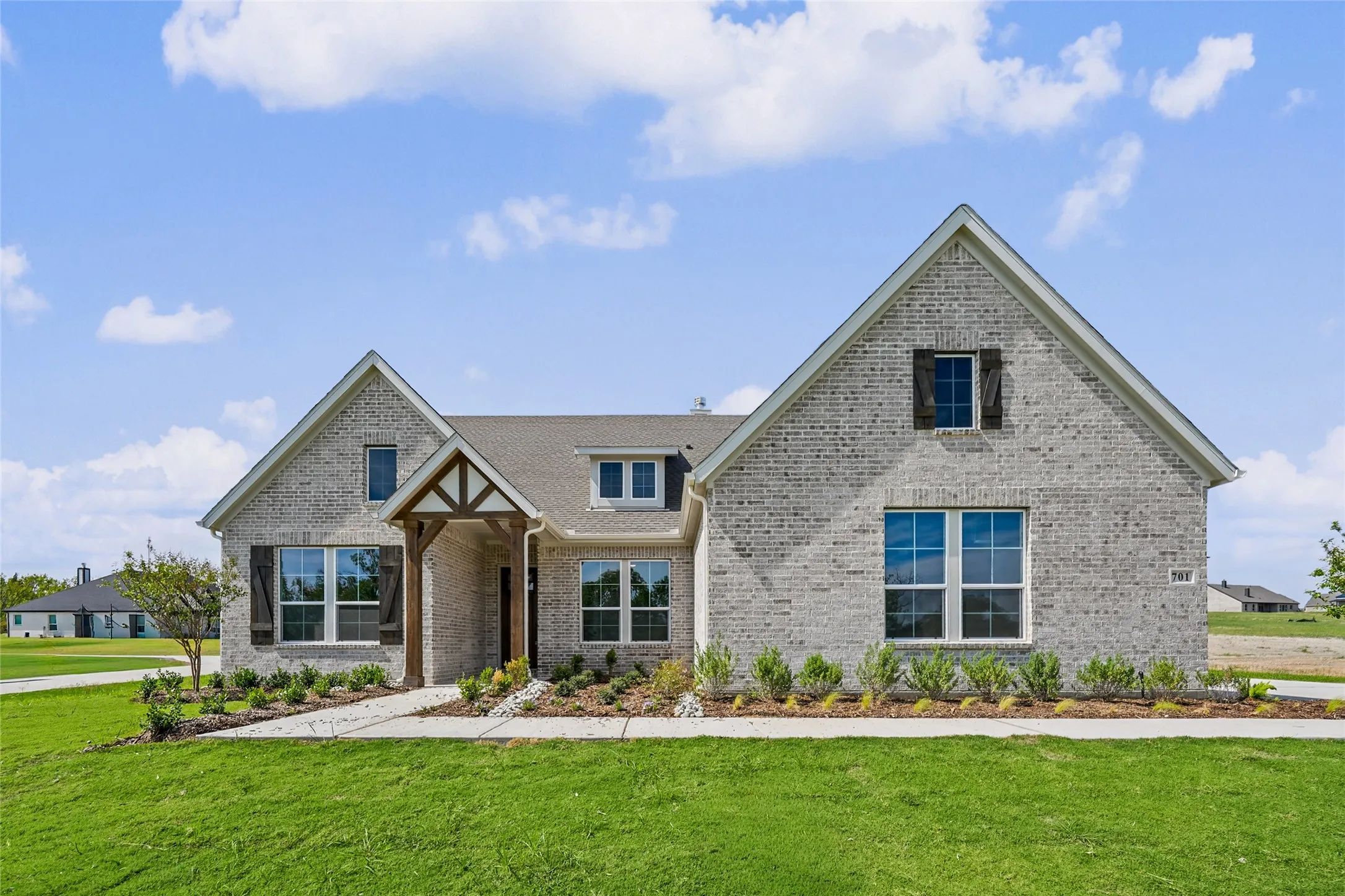 Gabled rooflines with stone veneer exterior and wood-look shutters