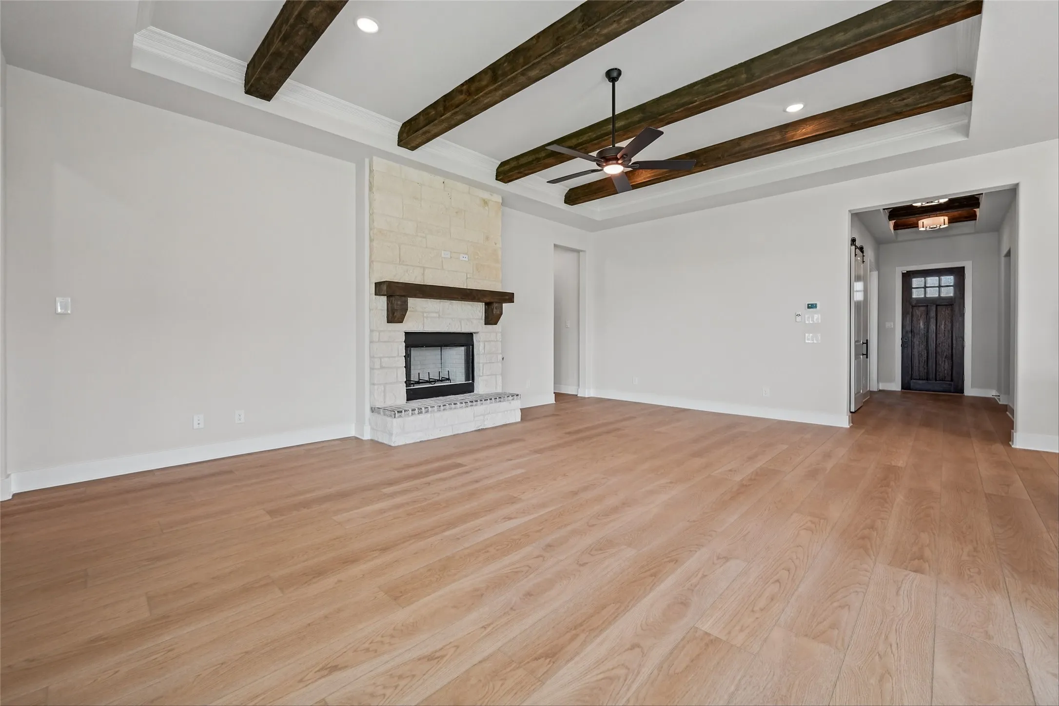 Tray ceiling with exposed wood beams and recessed lighting