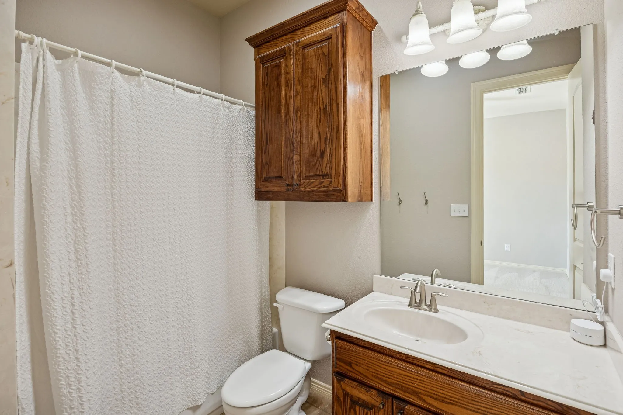 Ensuite bathroom with a bank of built in solid wood cabinets behind the door.