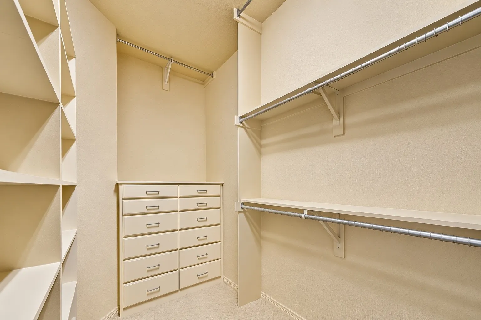 This secondary primary suite, or MIL suite, has a walk-in closet with built-in shelving, drawers, and hanging rods. Tons of storage in this custom home!