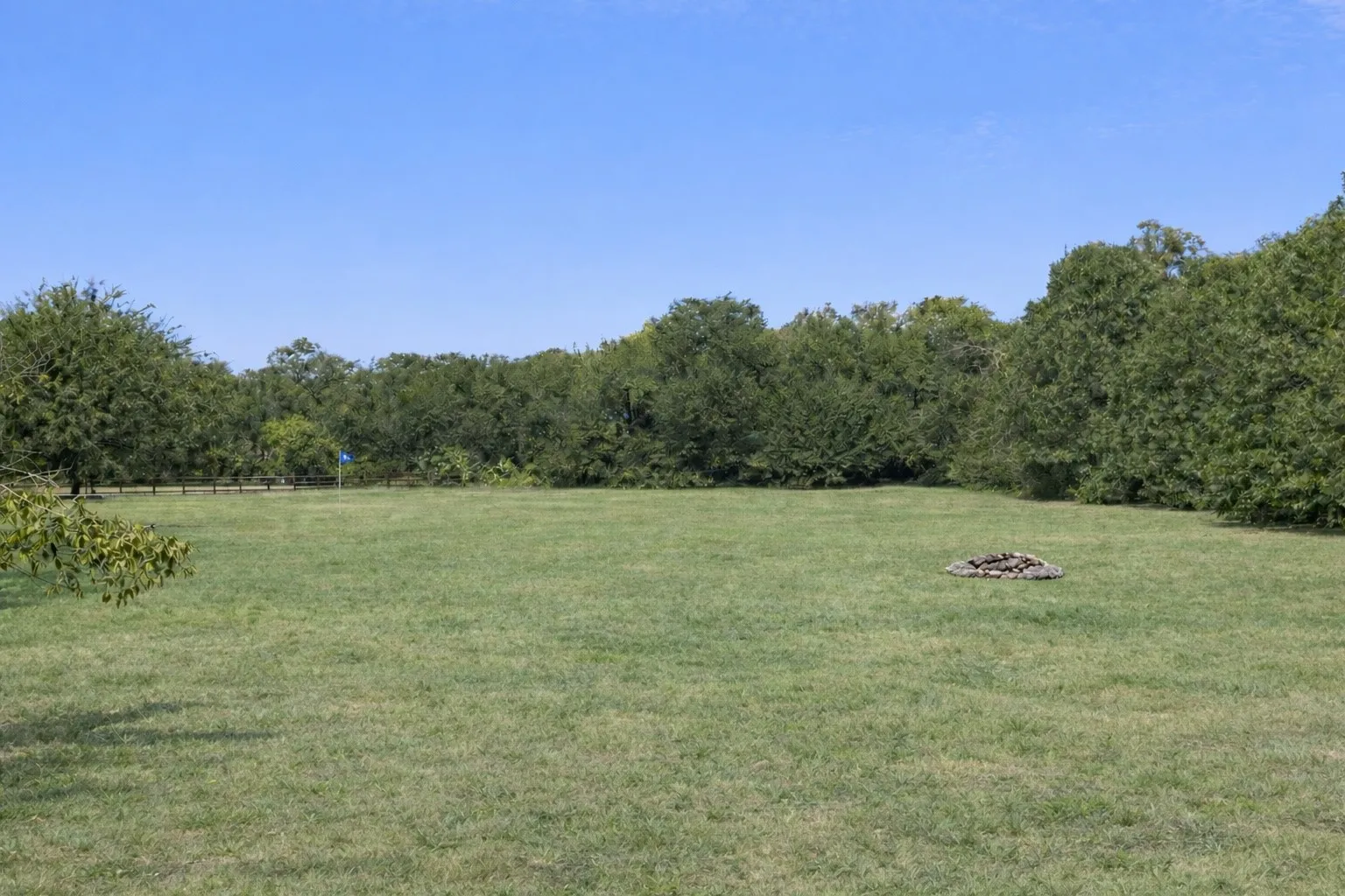 Wide-open backyard with endless possibilities—ideal for recreation, gardening, or creating your own outdoor oasis, all surrounded by natural tree lines.