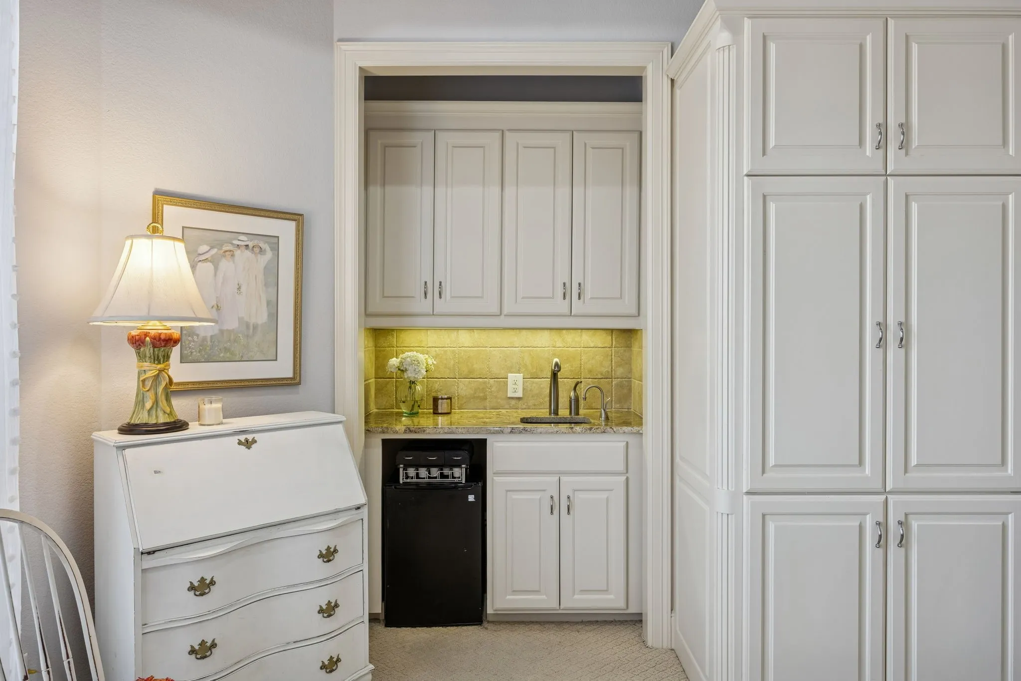 Wet Bar in second primary suite, or MIL suite, features mini-fridge, sink and quality cabinetry.