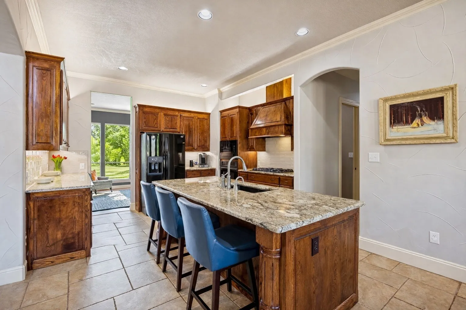 This well-appointed kitchen is open to the living room and has access to the formal dinging room (that is being used as a sitting room) offering a great entertaining flow. The kitchen features stunning solid wood cabinetry, a granite island with seating, and a gas range.