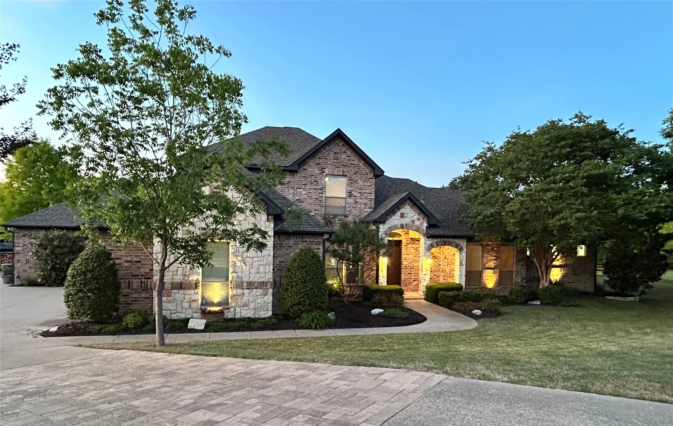 This stunning property features a beautiful brick and stone facade and an exceptionally well-maintained lawn with mature trees and landscape.
