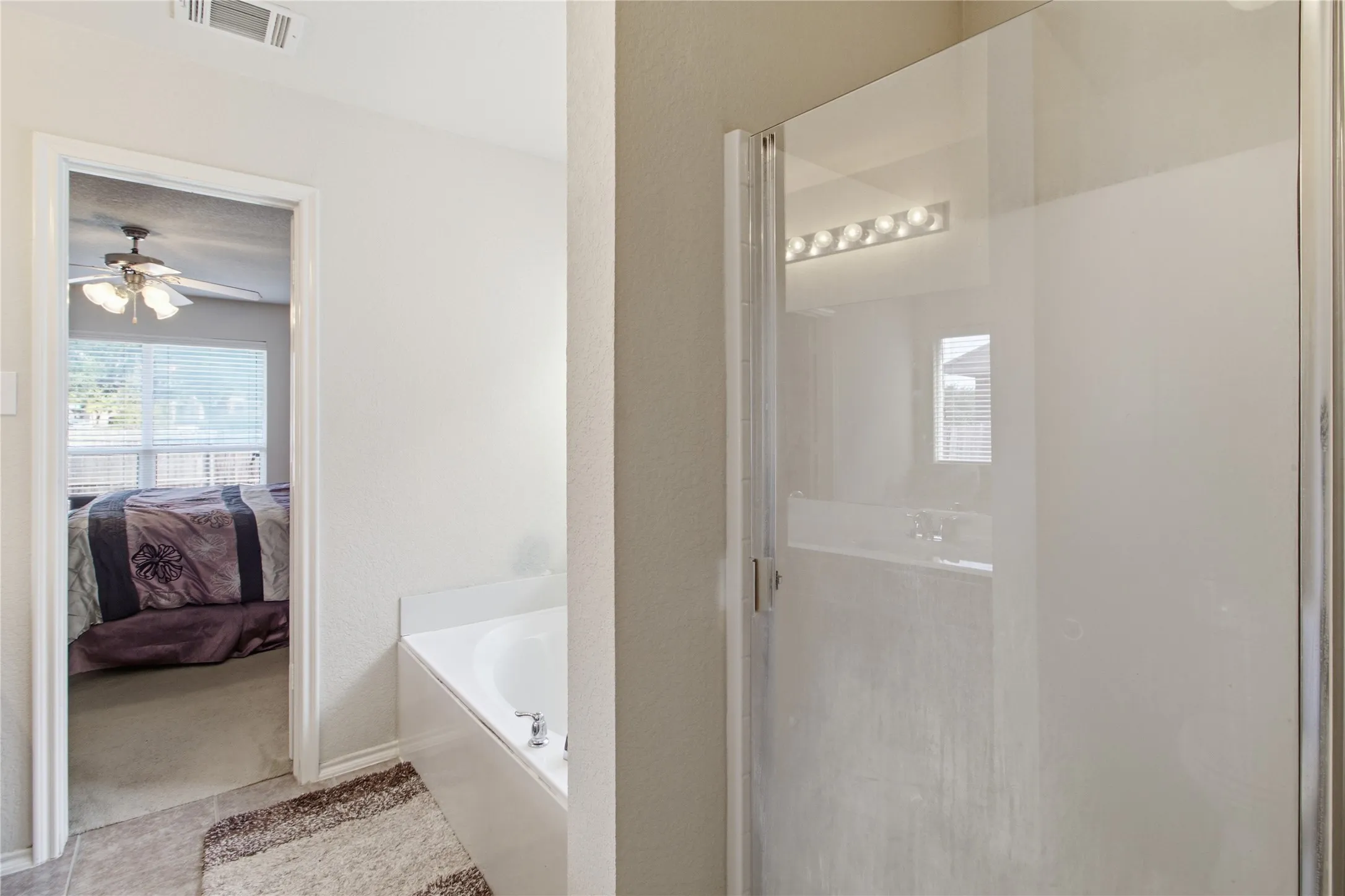 Enclosed shower with clear glass door and chrome trim