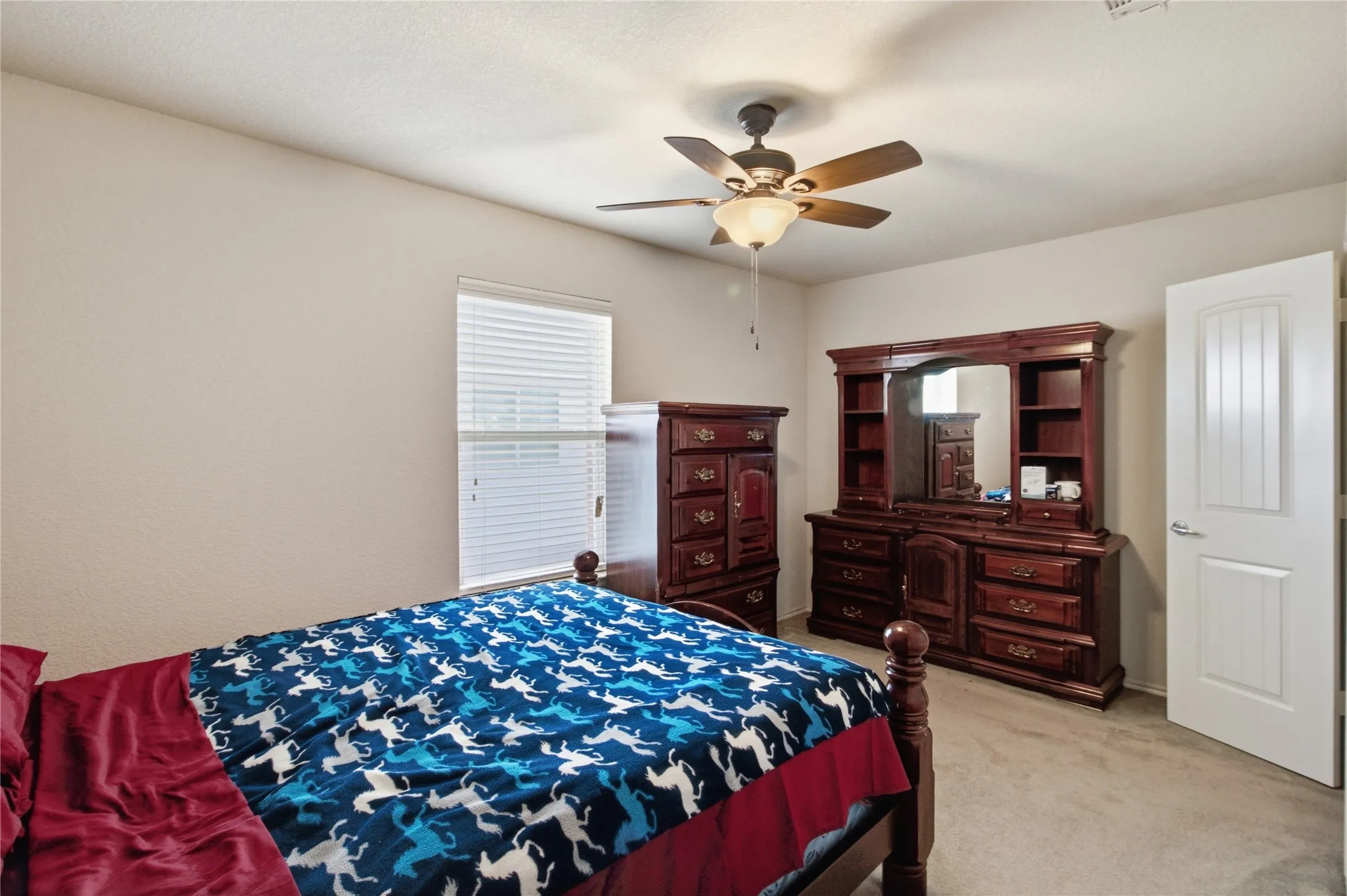 Bedroom featuring neutral wall tones, a ceiling fan with integrated lighting, and carpet flooring