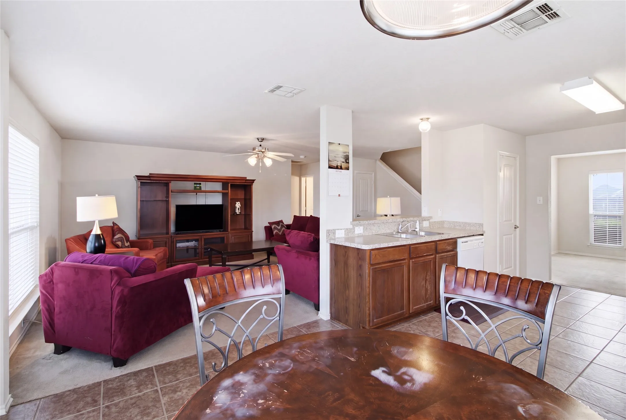 Open-concept living space featuring a breakfast bar with stone countertops and wood cabinetry
