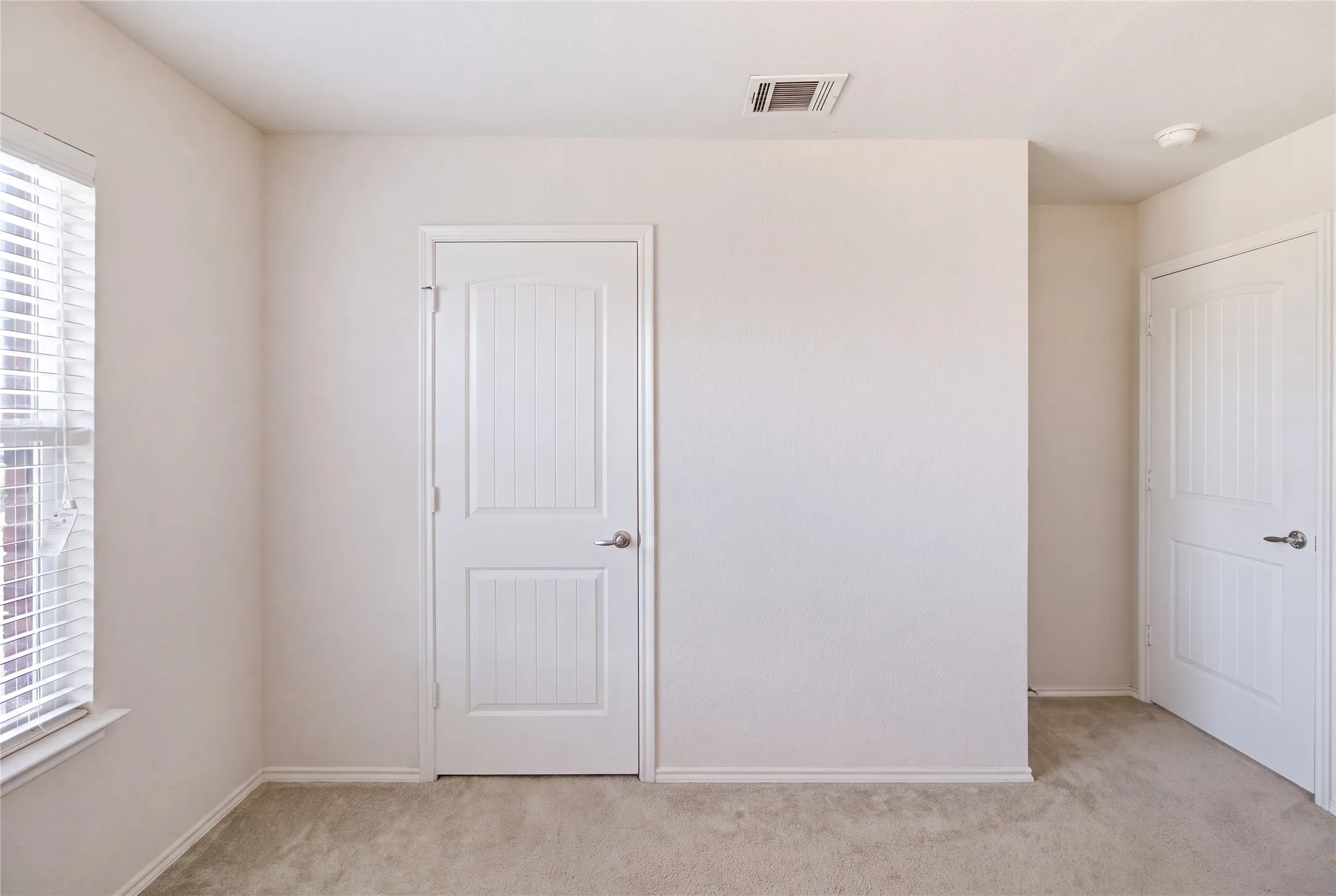 Neutral tone walls with white trim and carpeting