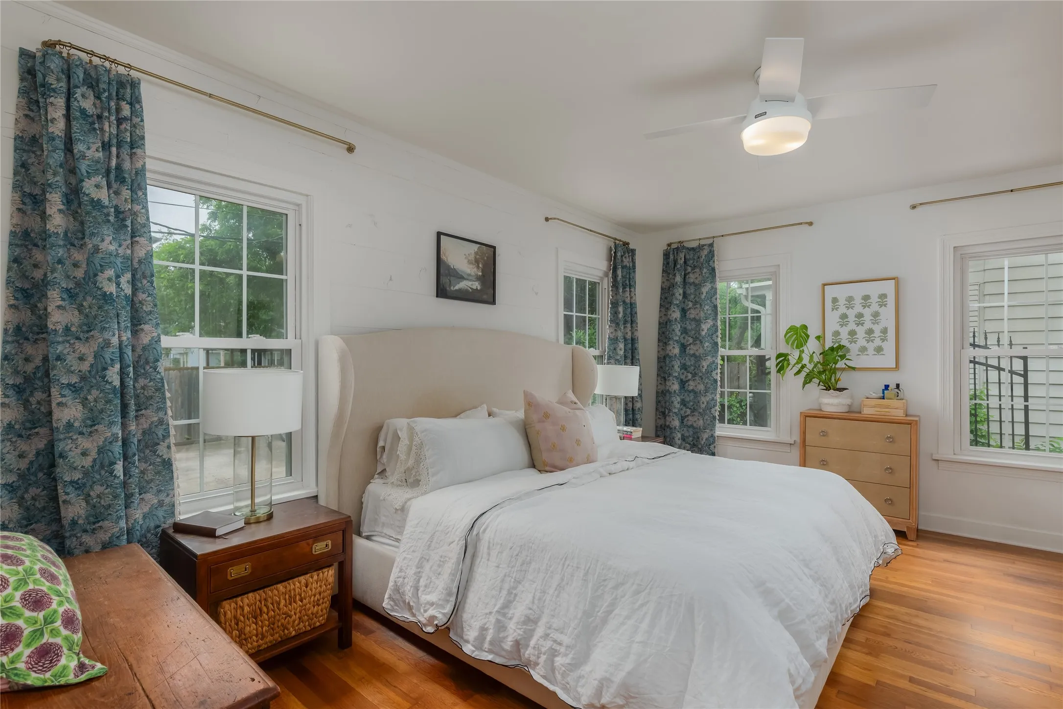 Hardwood flooring throughout featuring white walls and multiple windows
