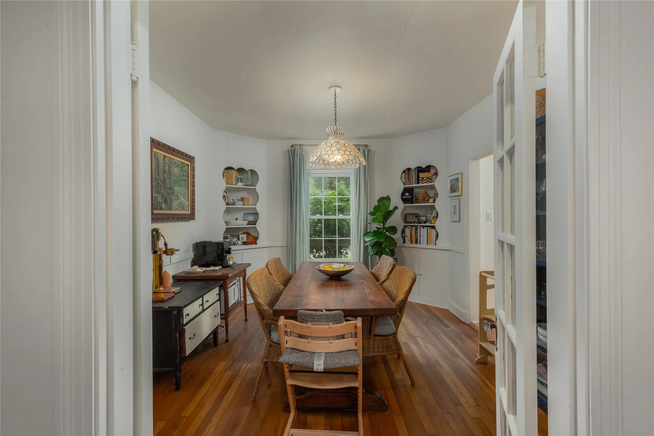 Hardwood flooring throughout the room, showcasing a decorative ceiling light fixture