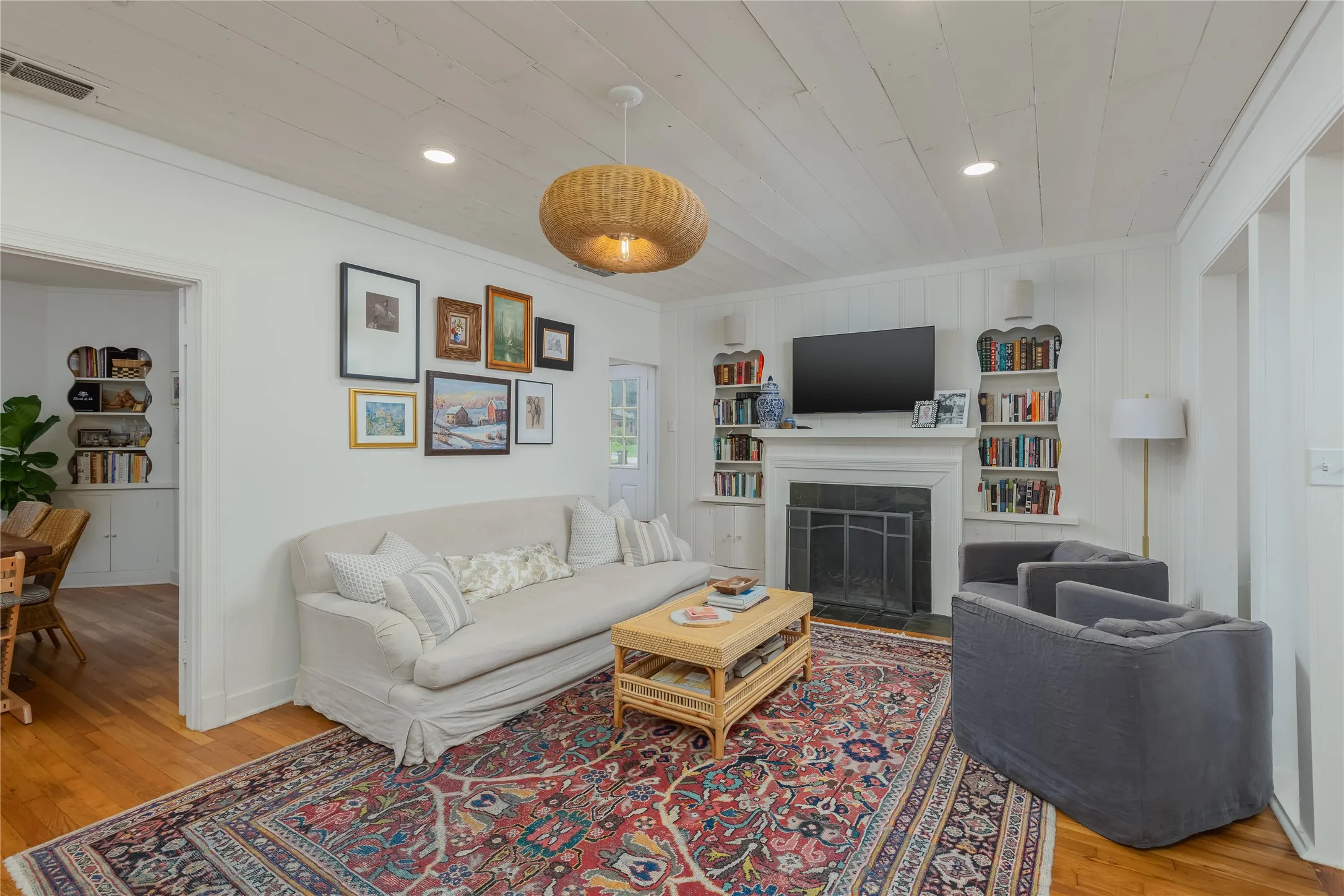 Living area featuring a fireplace with a dark stone surround and white mantel, flanked by built-in shelving