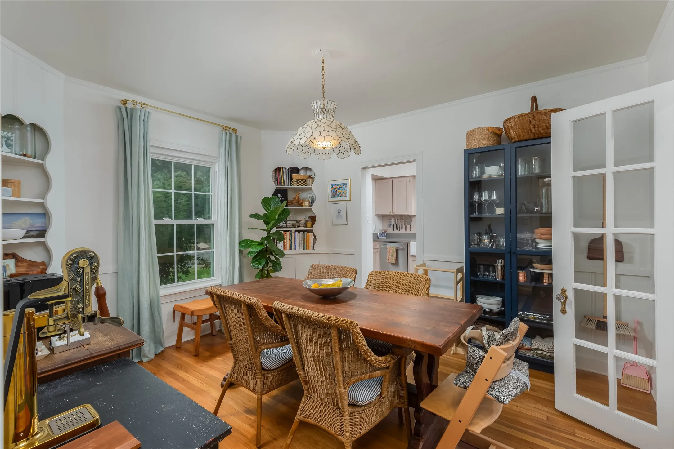 Hardwood flooring throughout this dining area, featuring a decorative ceiling light fixture