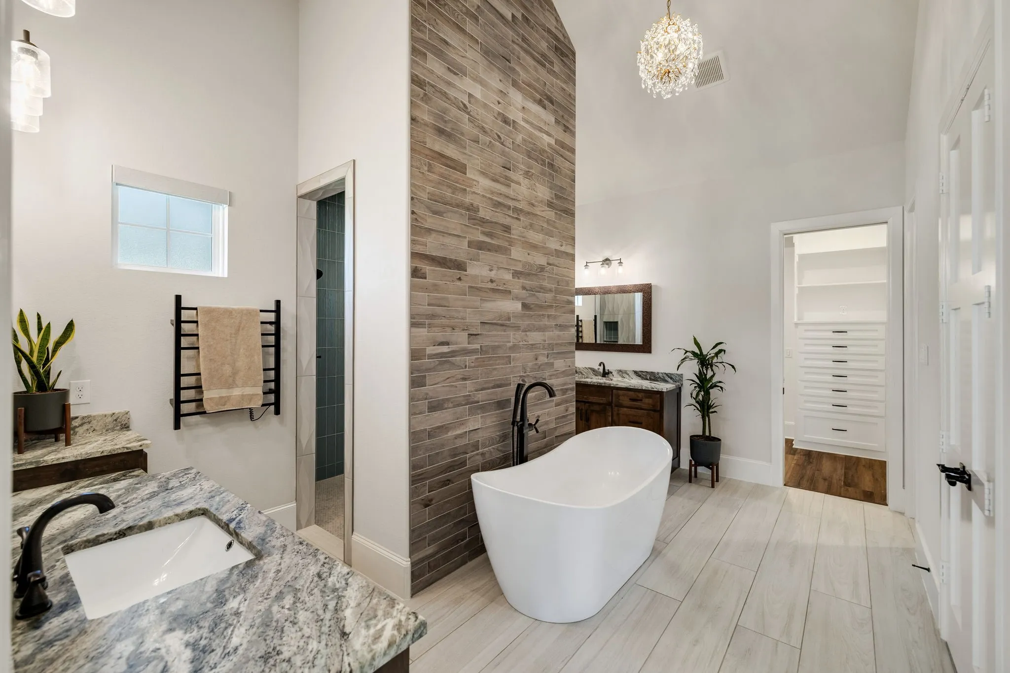 Freestanding soaking tub with a floor-mounted matte black faucet