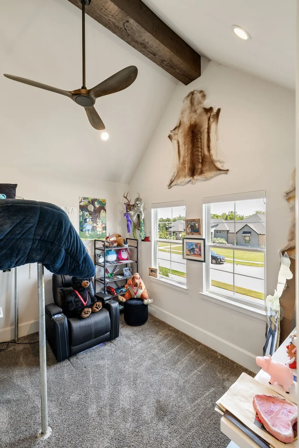 Vaulted ceiling room with wall-mounted television, gray carpeting, white trim, and a built-in loft bed frame with ladder access