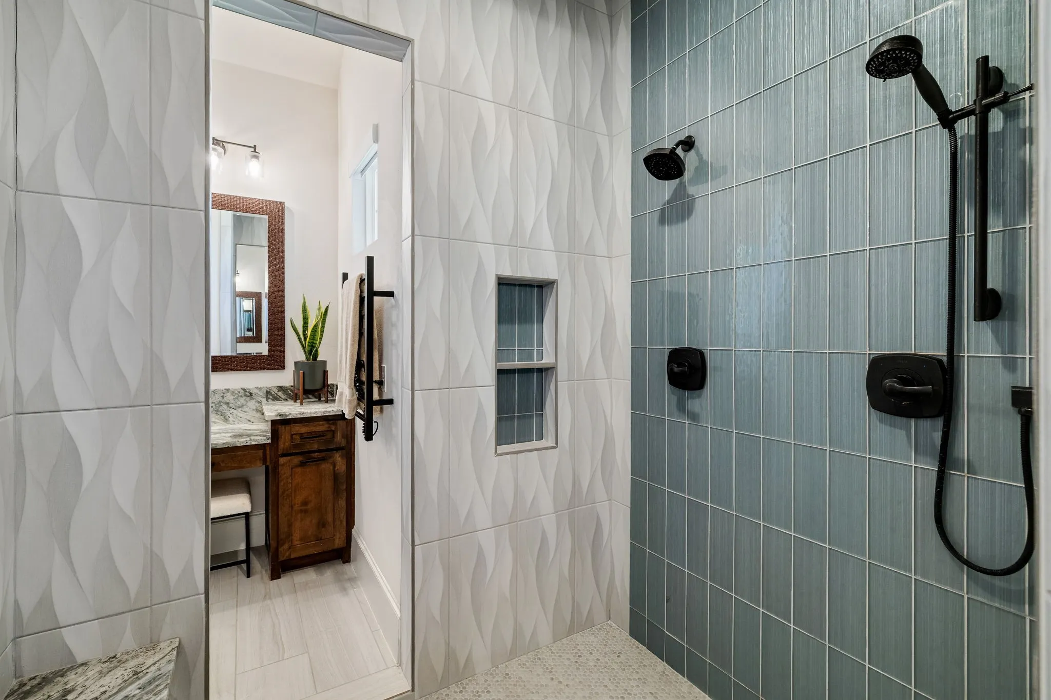 Walk-in shower featuring dual matte black showerheads and vertical blue subway tile