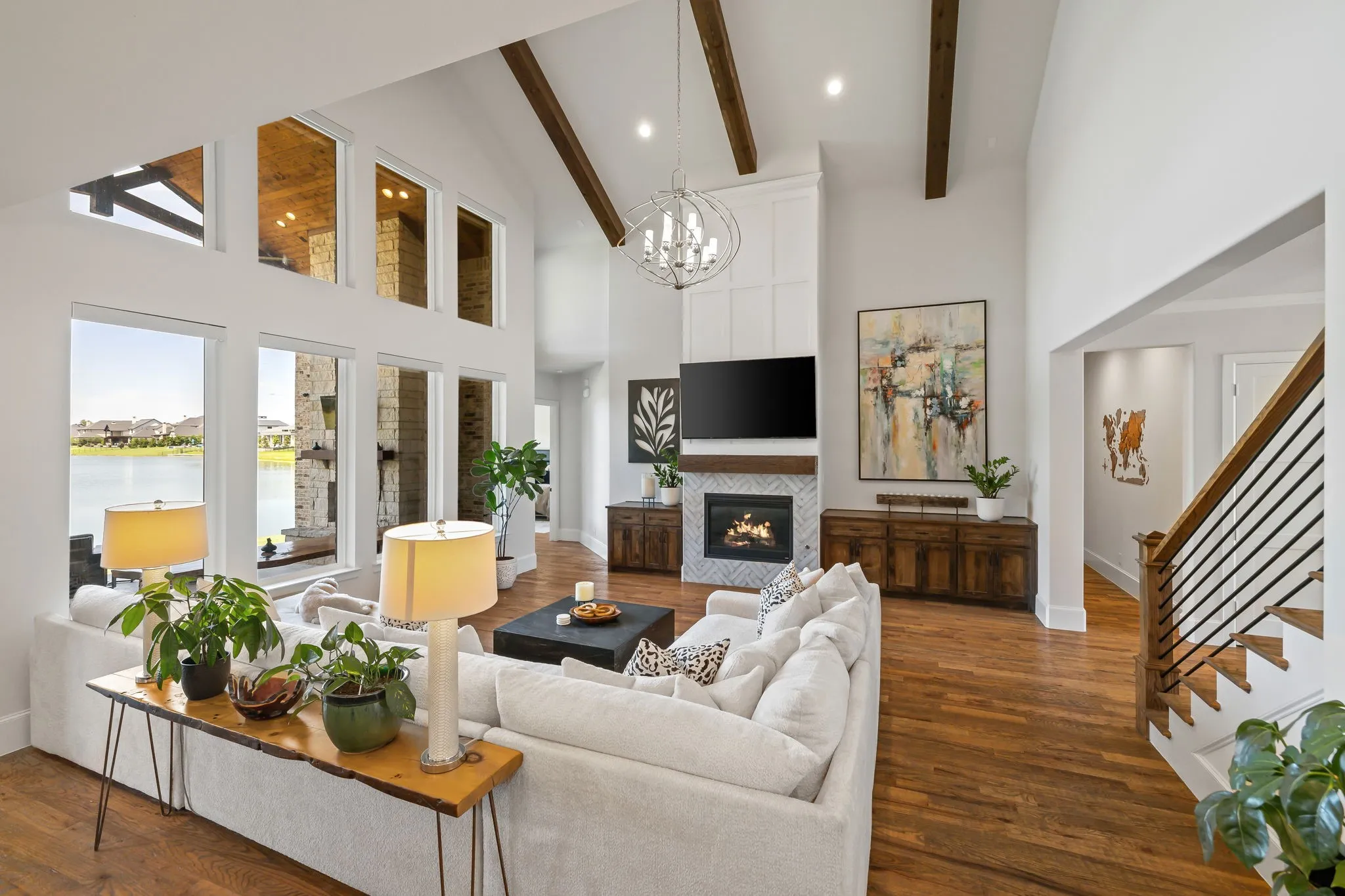 Living room featuring a vaulted ceiling with exposed wood beams, a fireplace with a herringbone tile surround and paneling, and wood-finish flooring