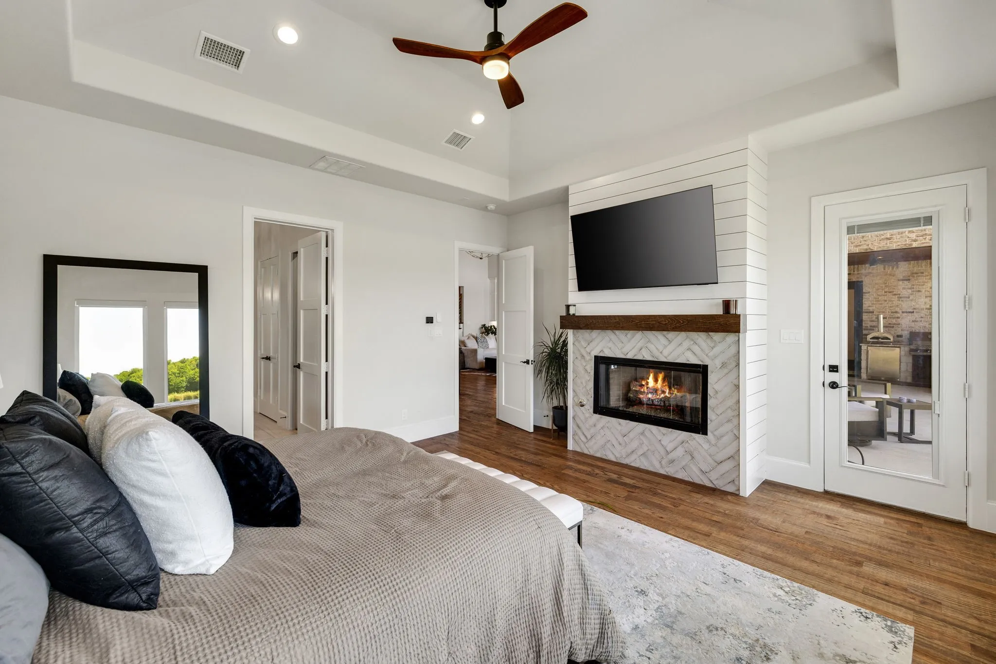 Room featuring a tray ceiling, recessed lighting, and wood-finish flooring
