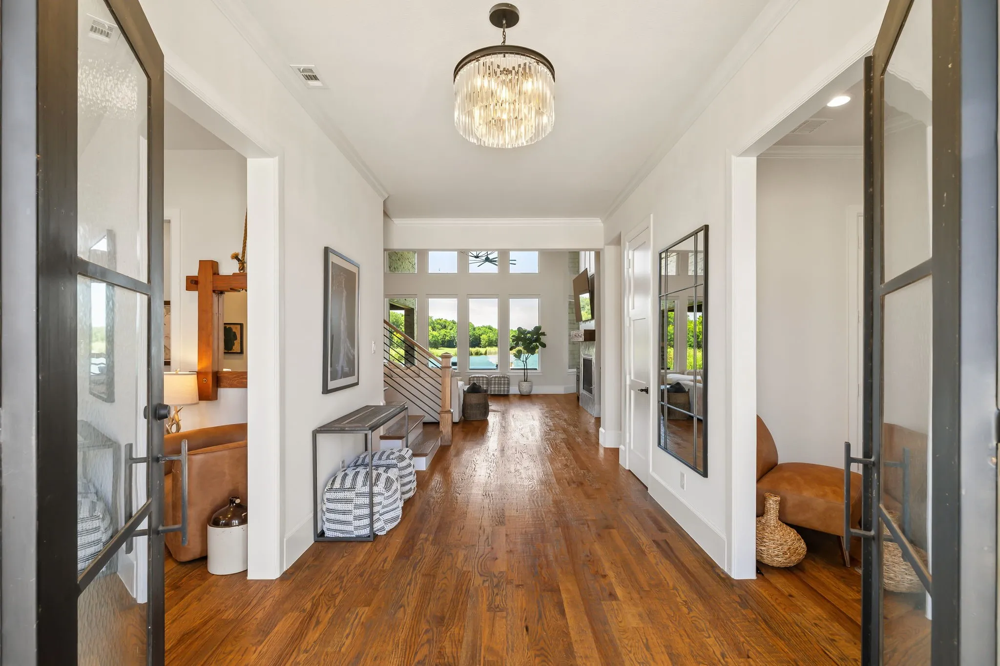 Double opening doors enter into a wide foyer welcoming you with a view of the waterfront landscape beyond.