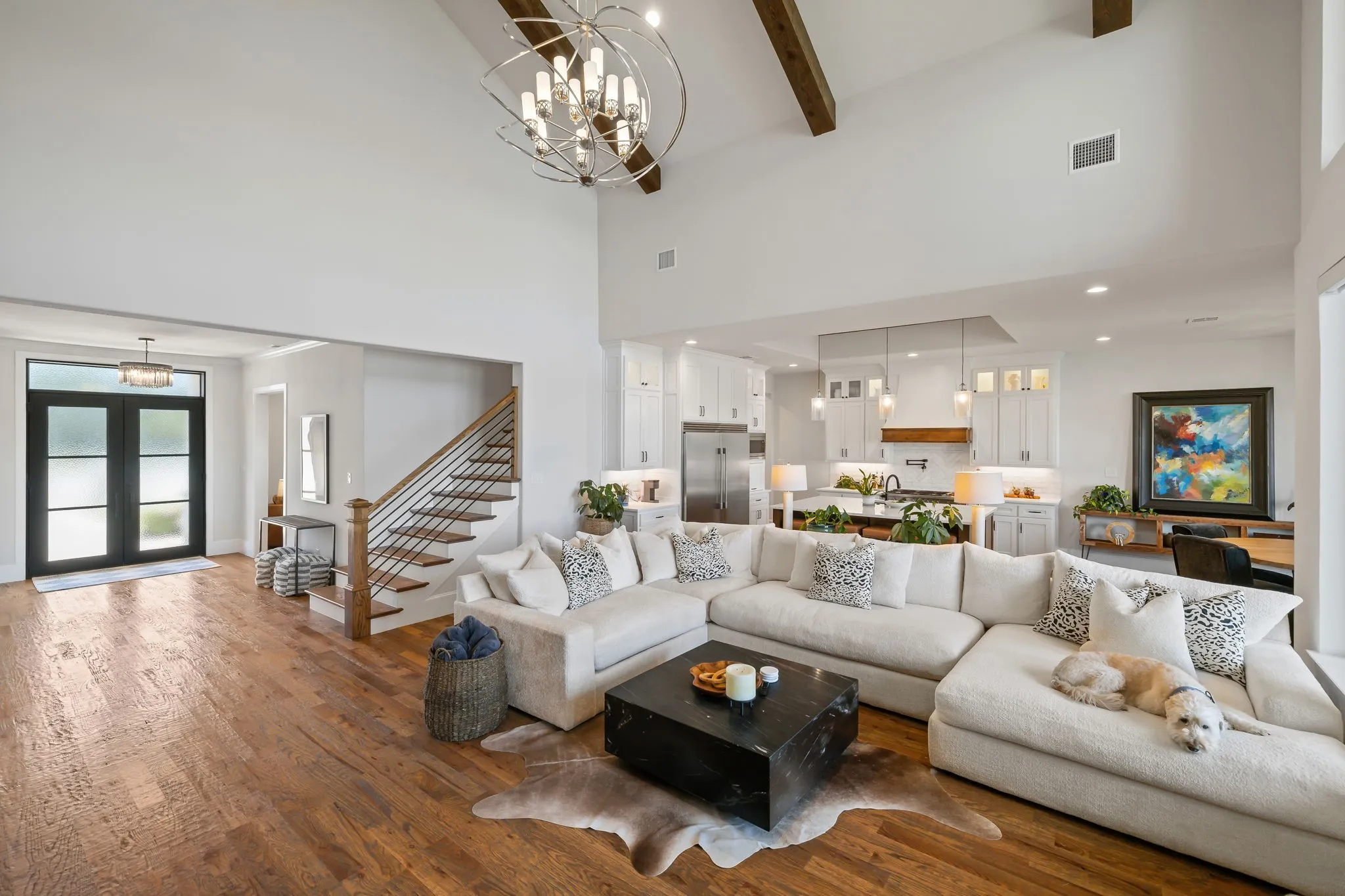 Spacious living area featuring high vaulted ceilings with exposed wood beams and wood-finish flooring