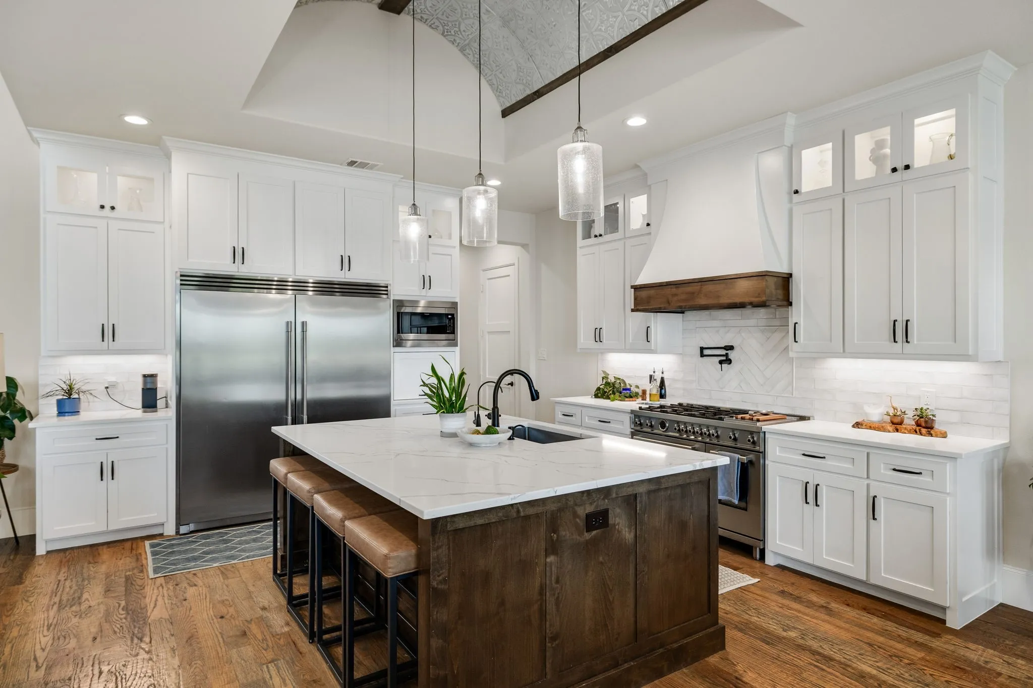 Gourmet kitchen with a central island featuring a marble-finish countertop, custom cabinetry, and commercial-style appliances