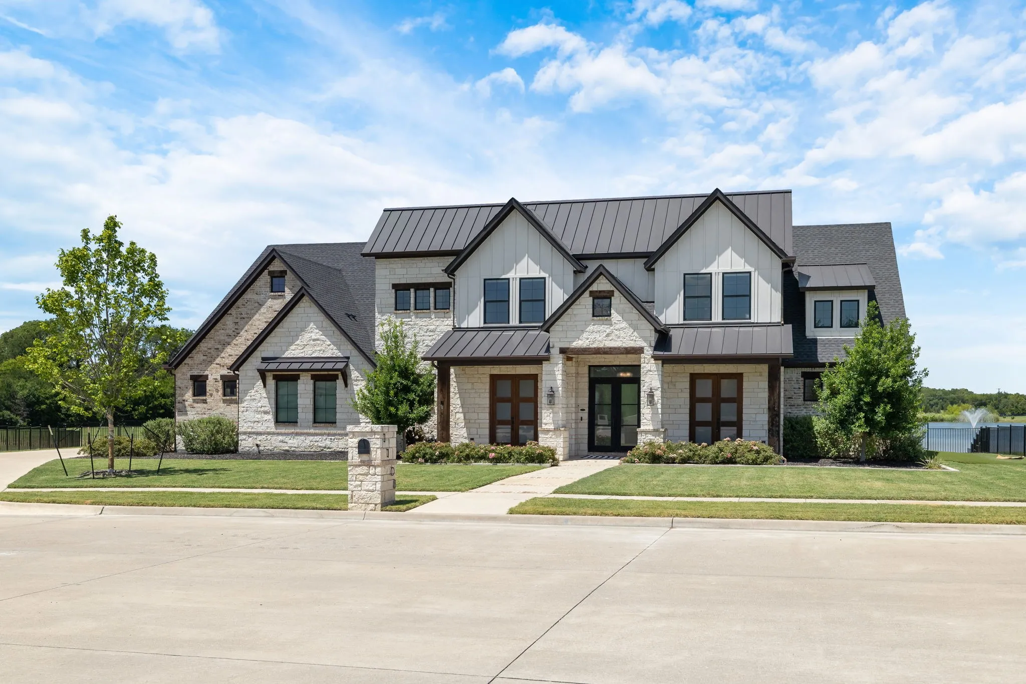 Modern farmhouse exterior featuring light stone and vertical white siding