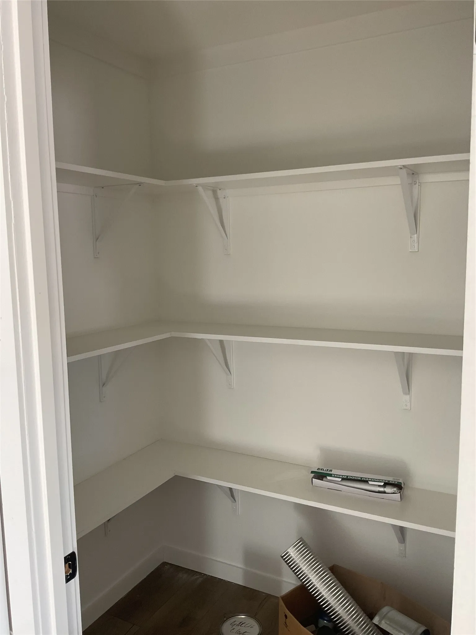 White shelving units, white walls, and wood-finish flooring