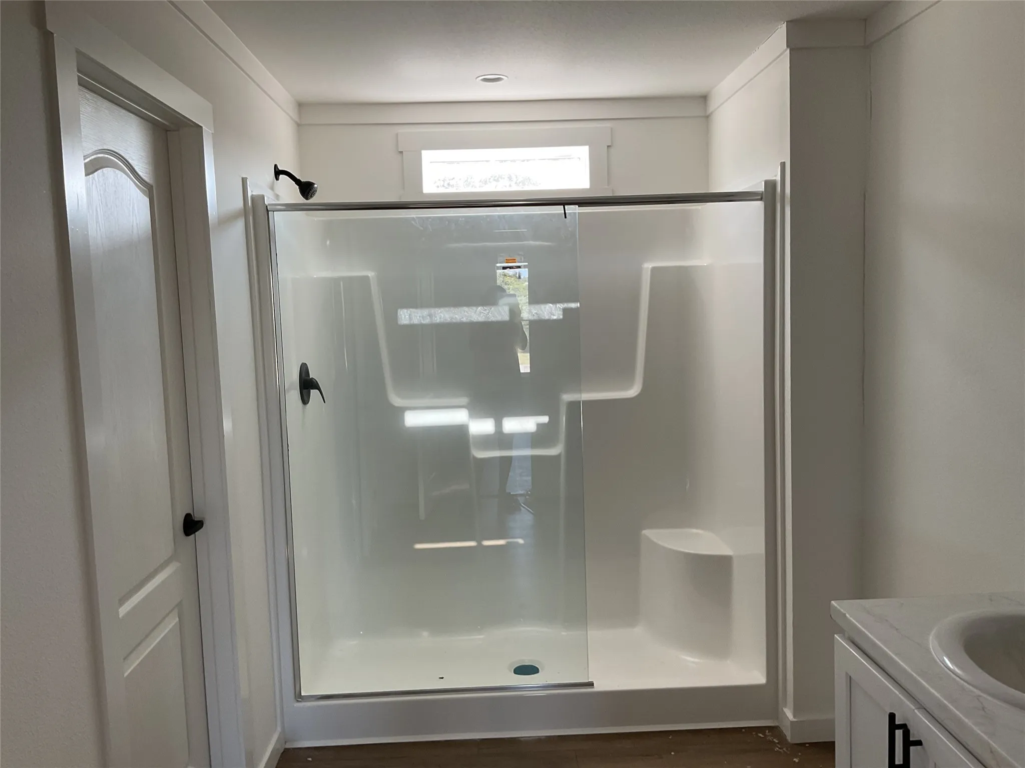 Walk-in shower with clear glass enclosure and integrated seating