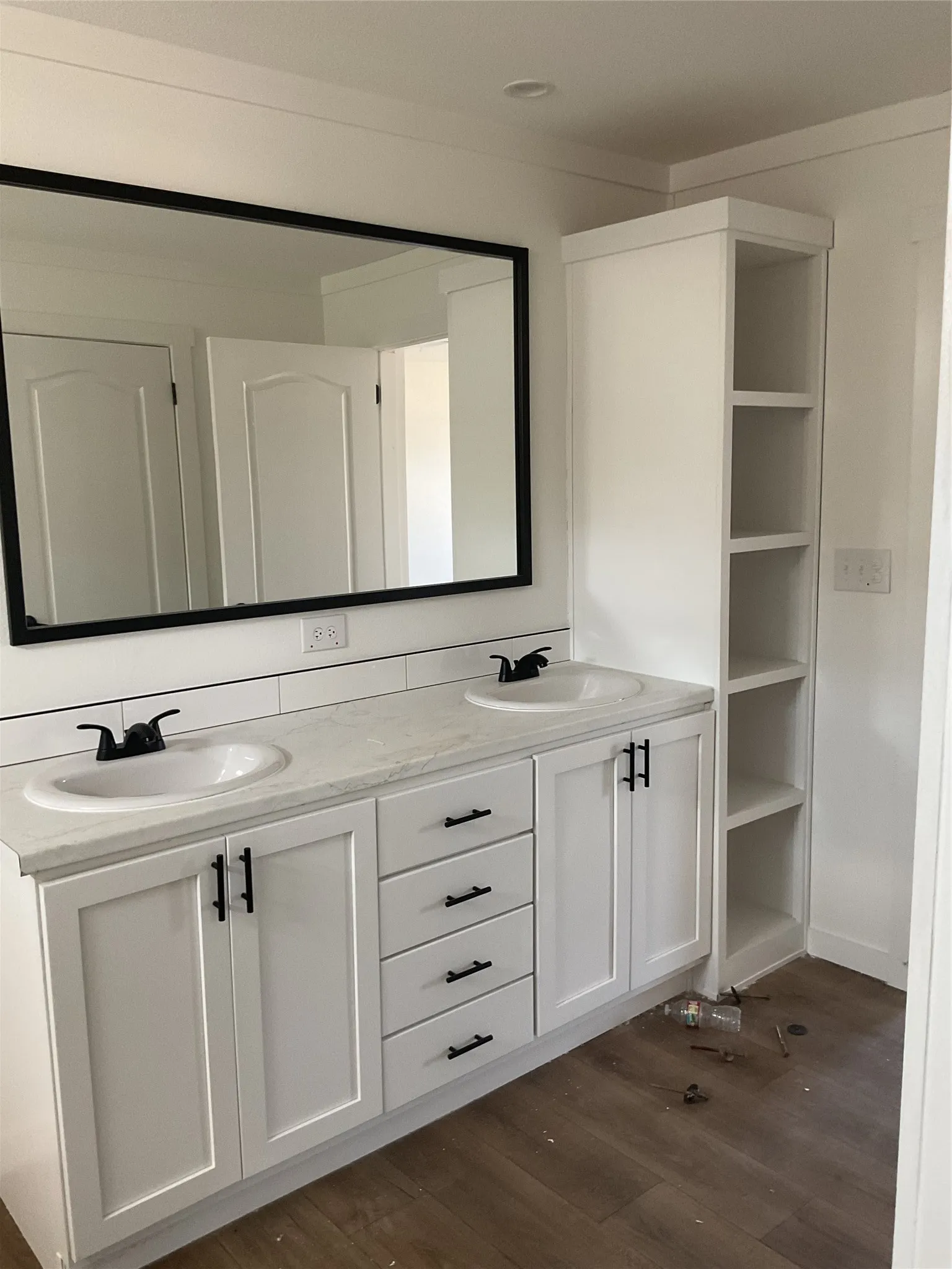 Dual vanity with white shaker-style cabinetry, matte black hardware, and integrated sinks