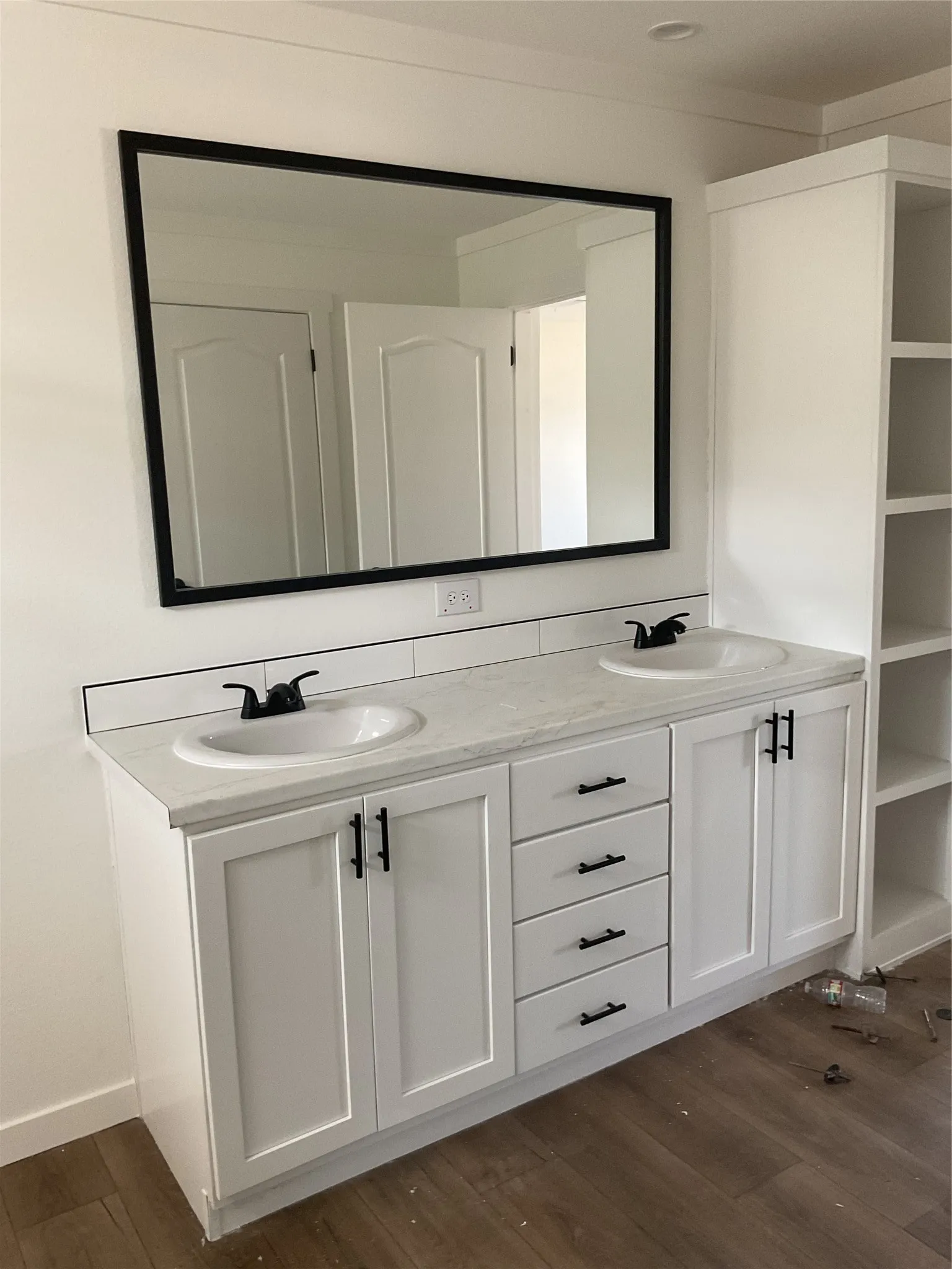 Dual vanity with white shaker-style cabinetry, matte black hardware, and light-toned countertops