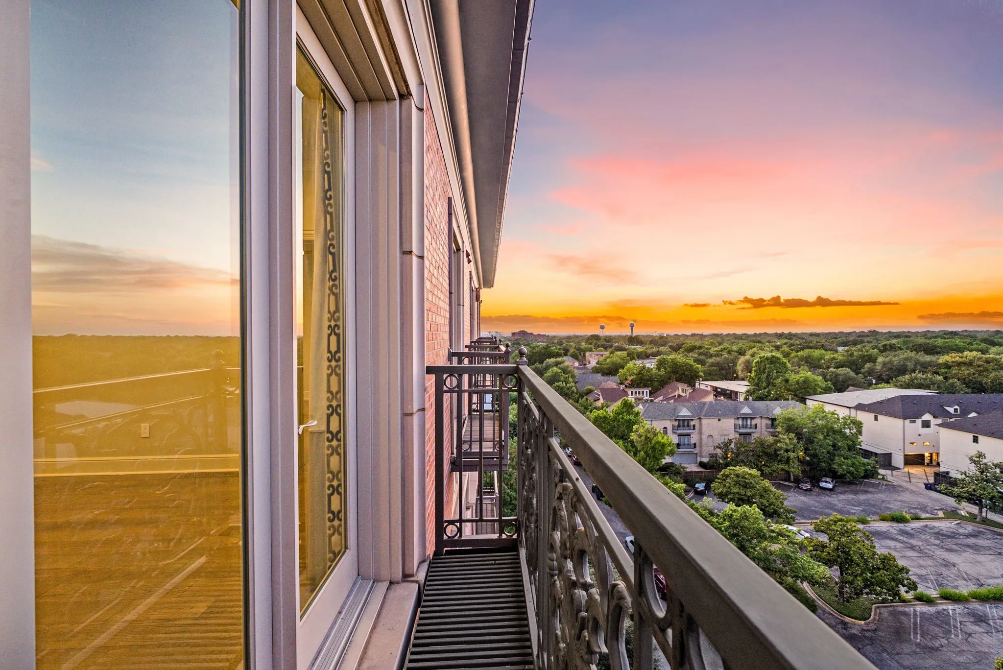 Balcony with ornate metal railing and expansive treetop scenery