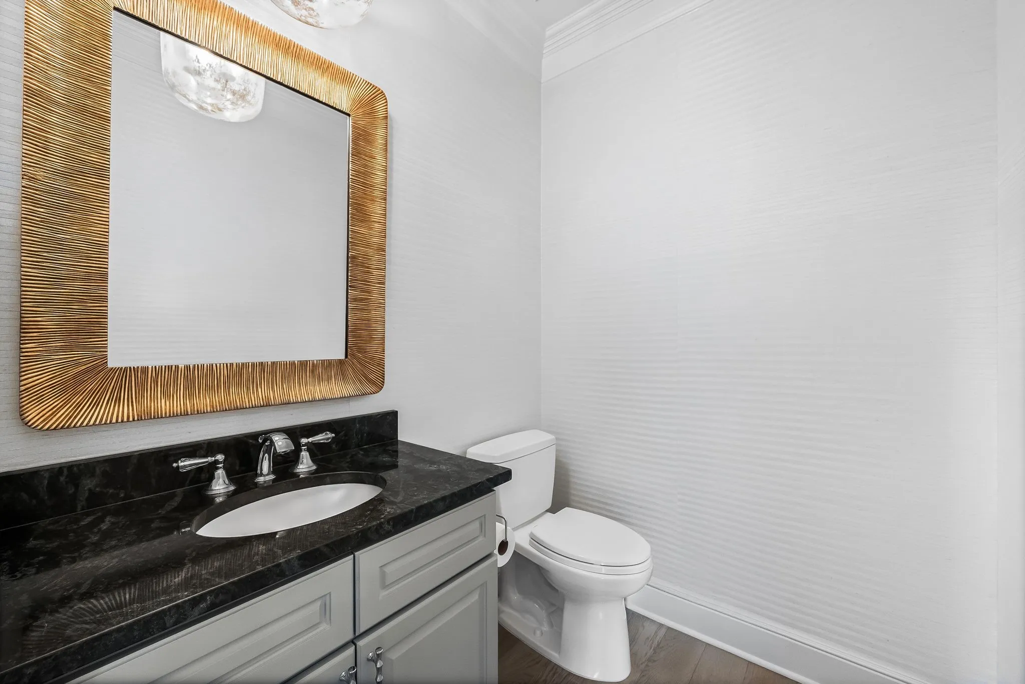 Vanity featuring a dark stone countertop with an undermount sink and chrome fixtures
