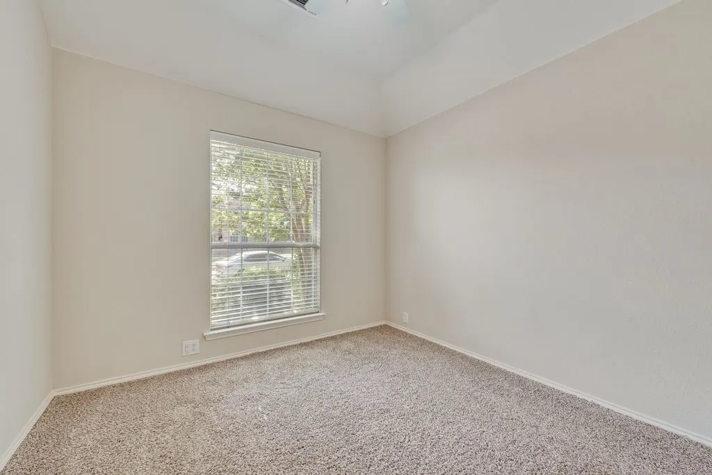 Carpeted room featuring a single window with blinds, a ceiling fan, and painted walls