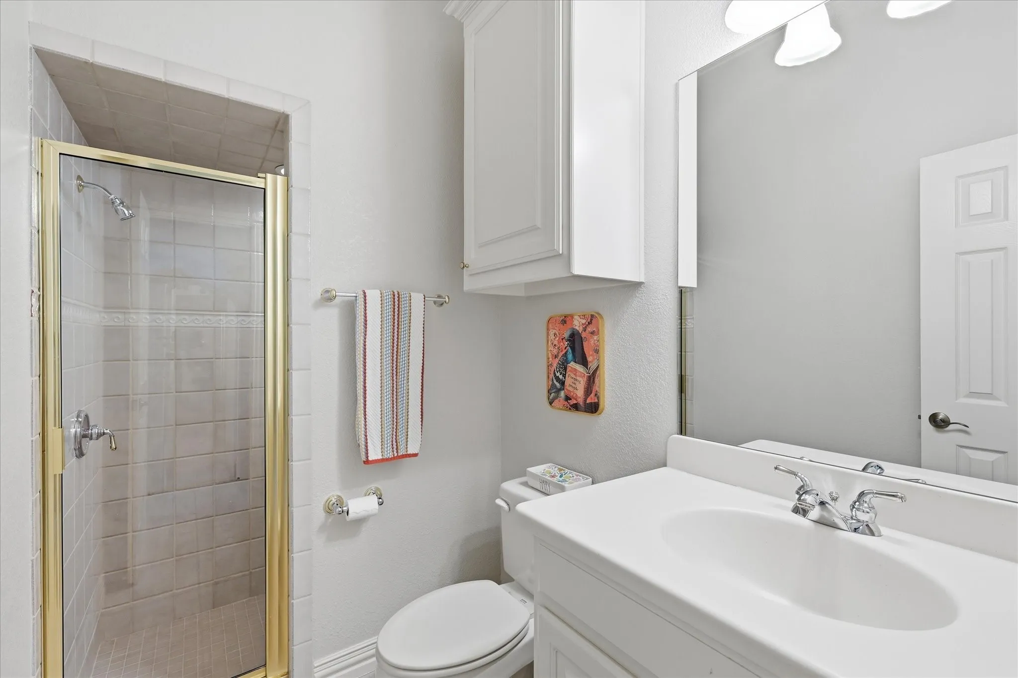 Bathroom 2. Mirrored, and cabinetry.