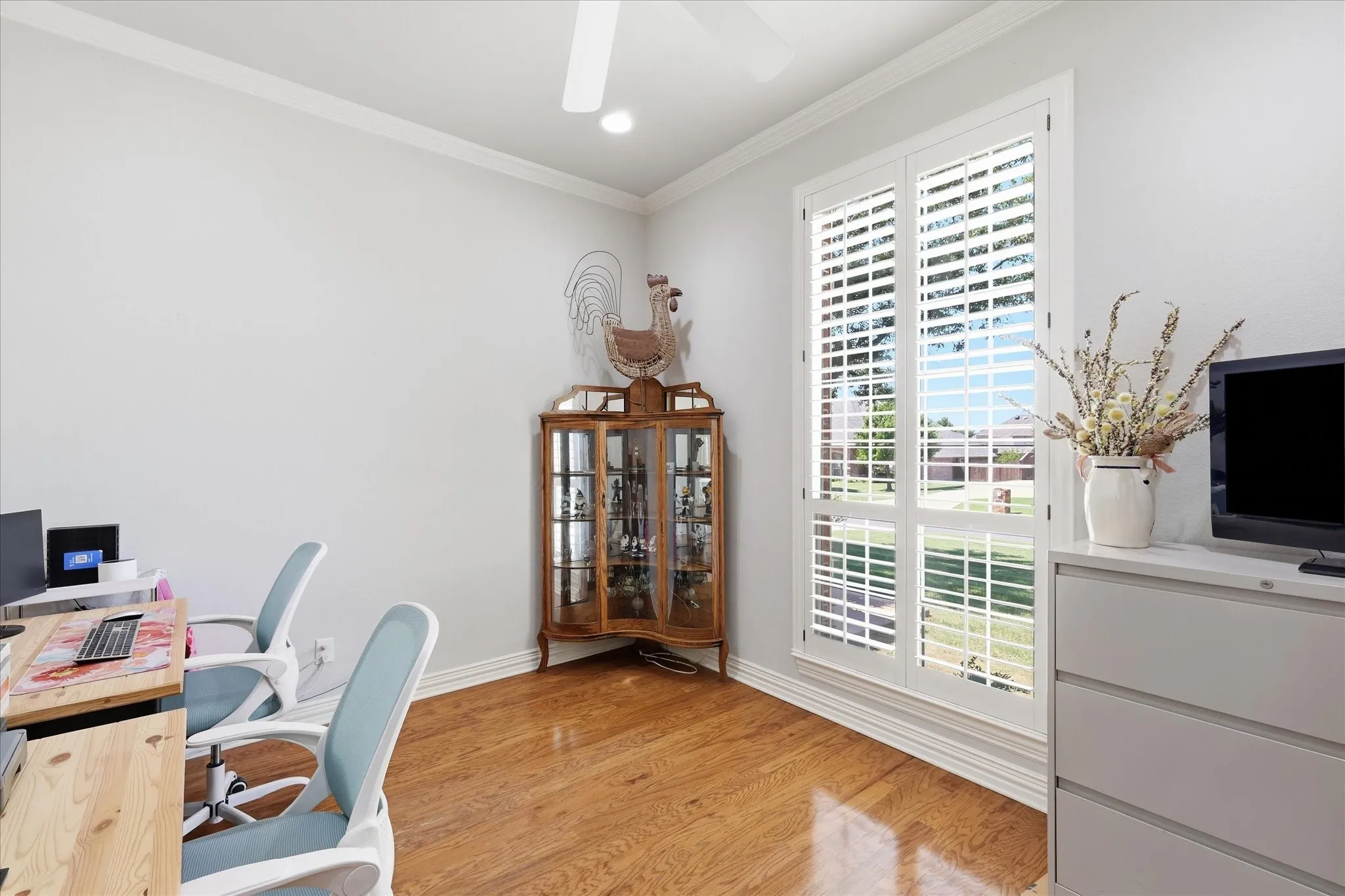A dedicated office with views to the street.  Plantation shutters on all windows in the home. Ceiling fan too.