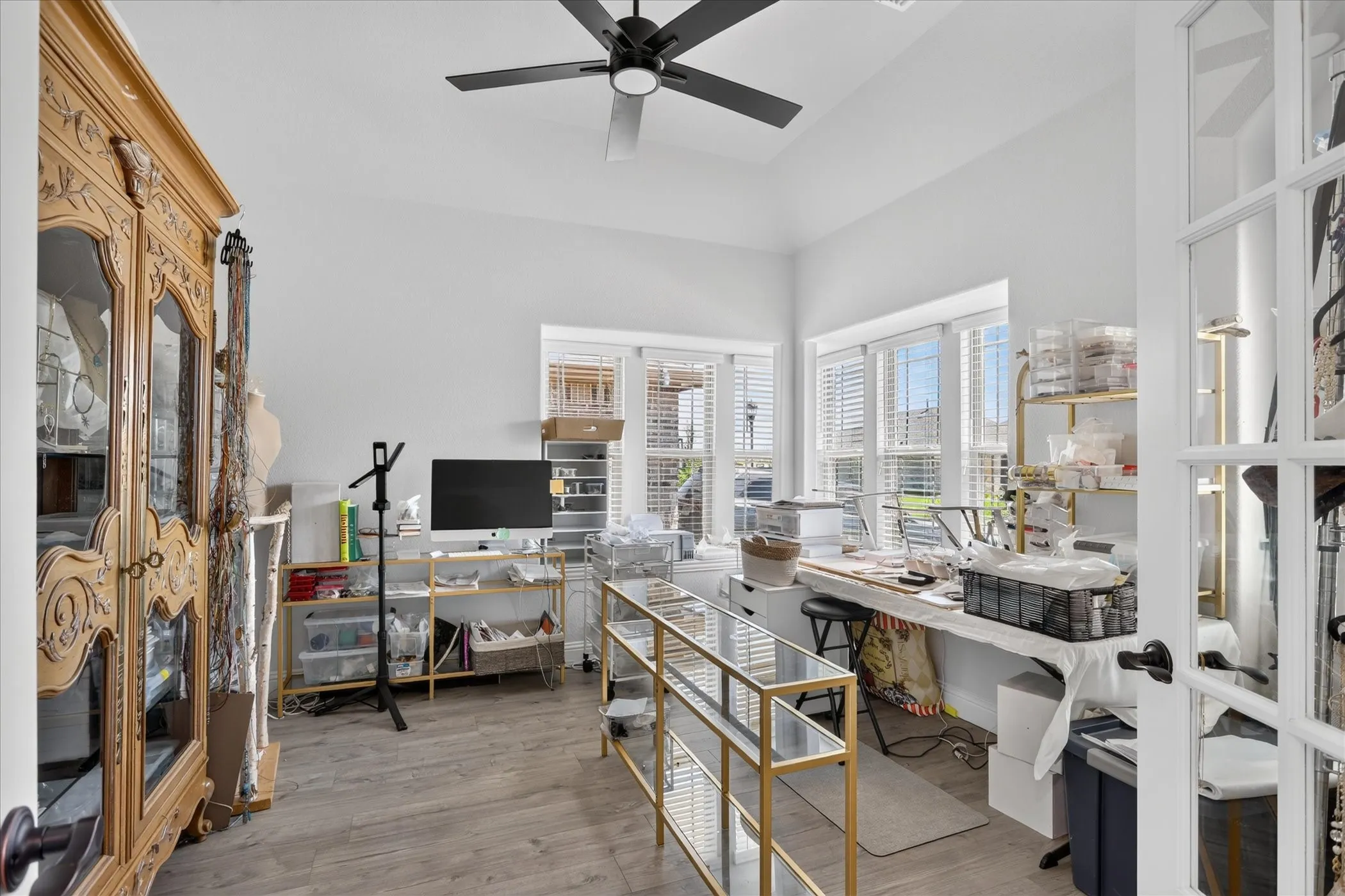Bright room with high vaulted ceilings and a black ceiling fan