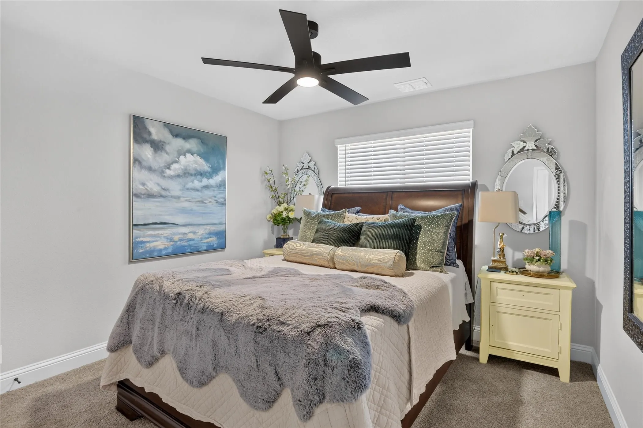 Bedroom featuring a dark wood bed frame, light gray walls, and carpet flooring