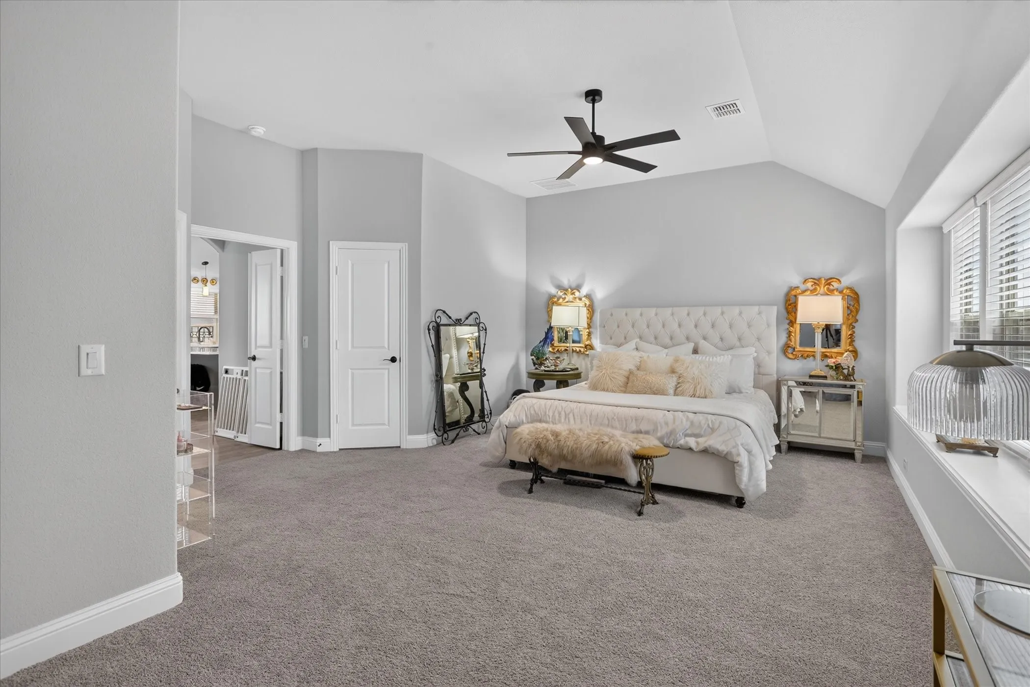 Carpeted room featuring a vaulted ceiling with a ceiling fan, a window with horizontal blinds, and white trim throughout