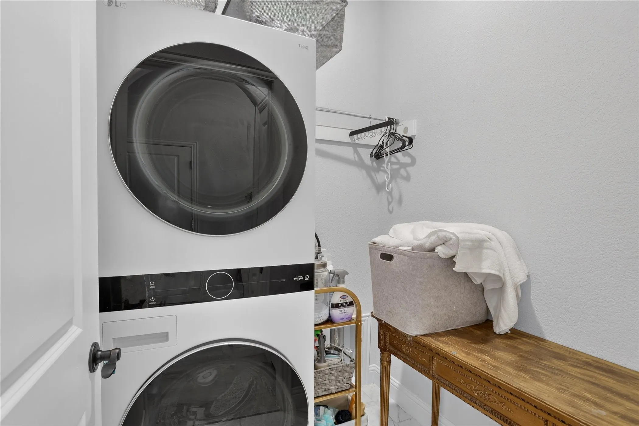 Vertical stackable washer and dryer unit with a light gray wall finish
