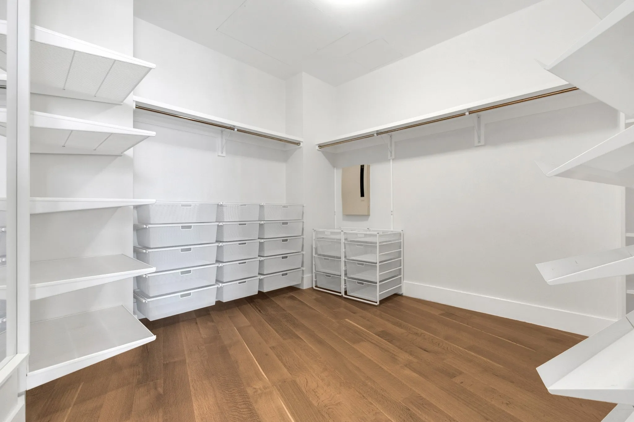 Hardwood-style flooring throughout with white walls and built-in shelving