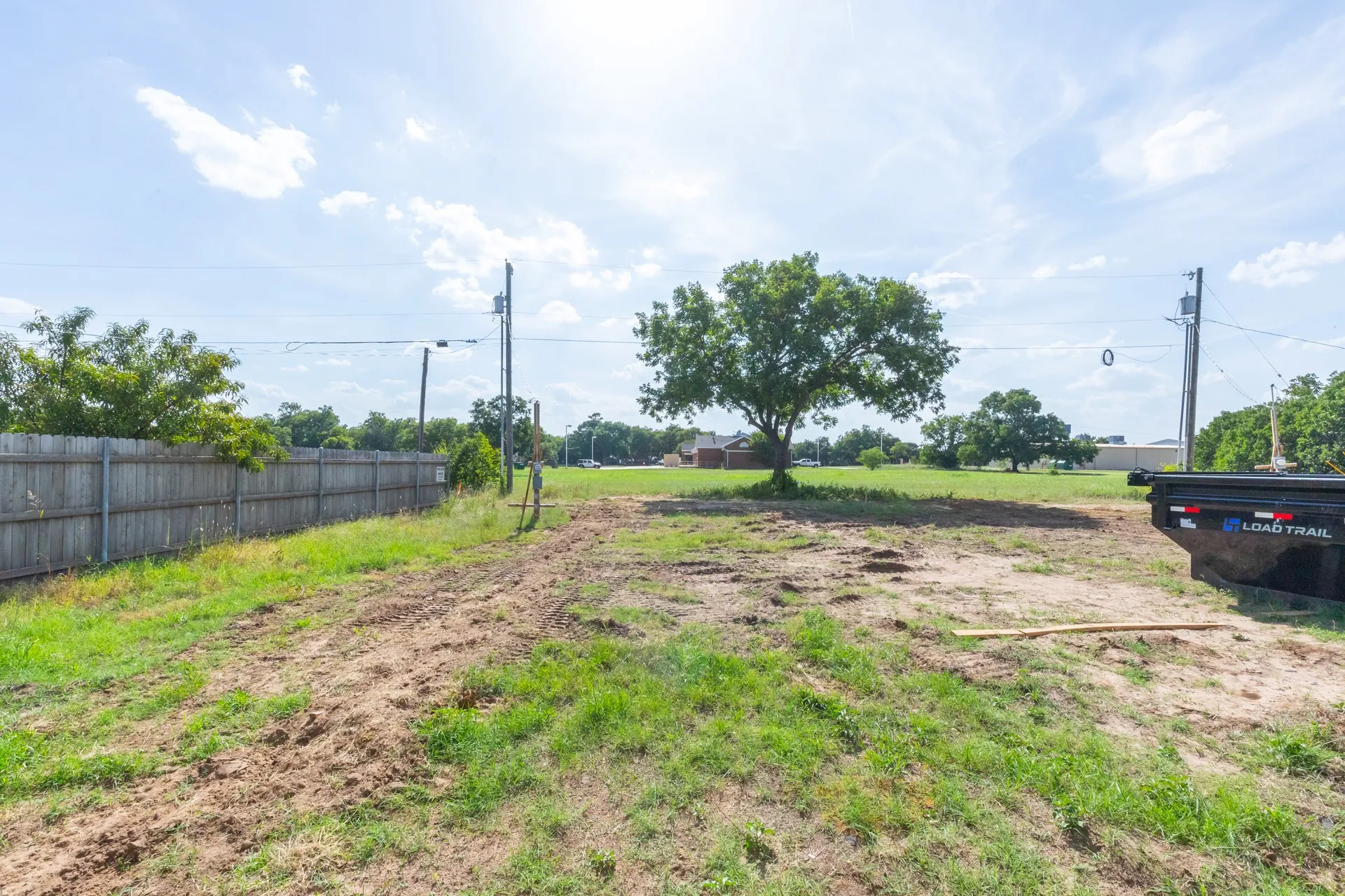 Expansive land parcel featuring existing perimeter fencing and mature trees