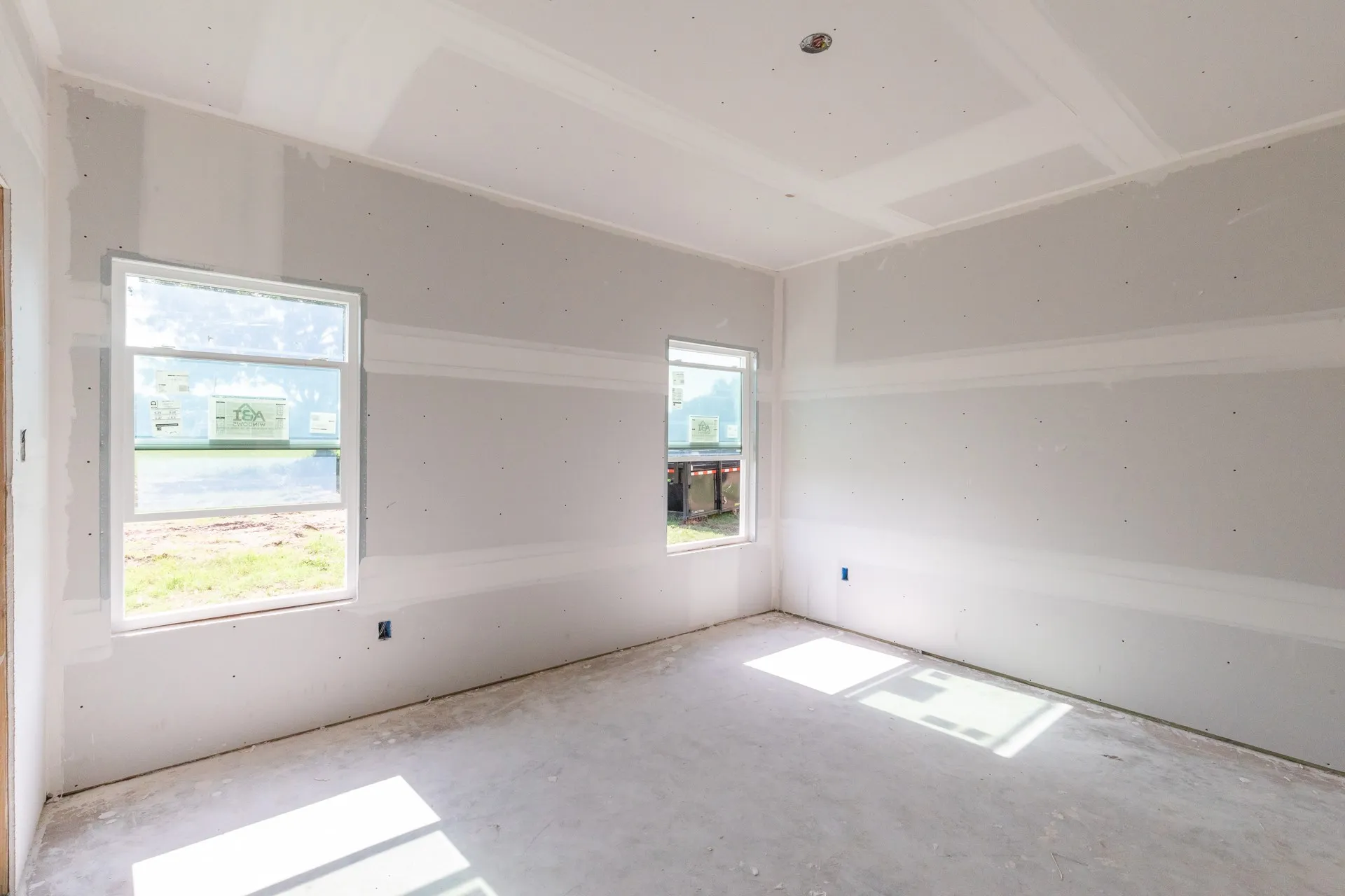 Room featuring two windows, recessed ceiling lighting, and drywall construction