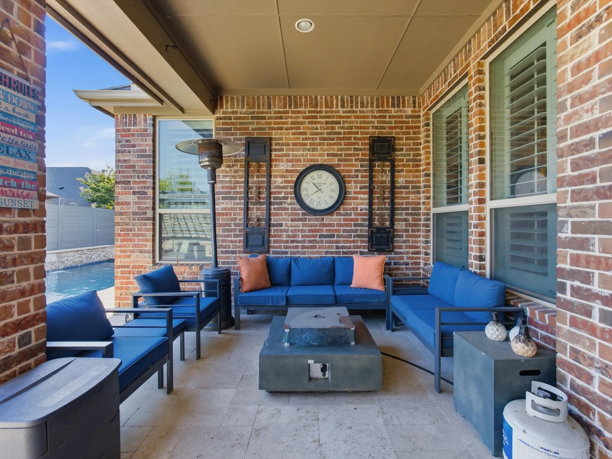 Covered patio featuring a brick exterior and a stone-look flooring