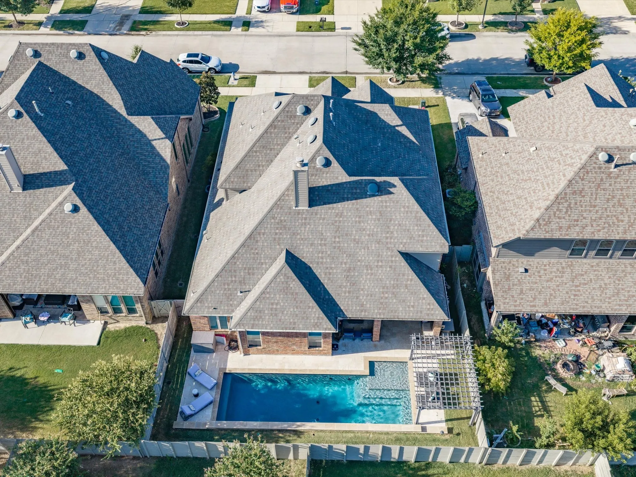 Aerial perspective showcasing a shingled roofline and a backyard oasis